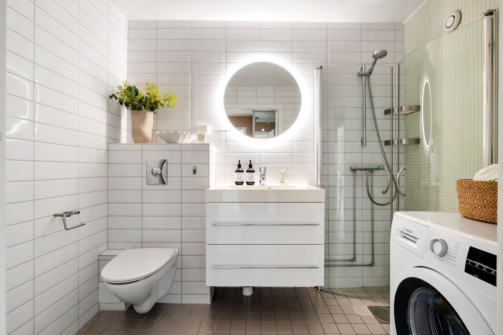 Leiligheten har et pent flislagt bad med downlights i himling og gulvvarme. Badet har også opplegg for vaskemaskin. Varmtvann kommer fra felles anlegg og er inkludert i fellesutgiftene Galleribilde