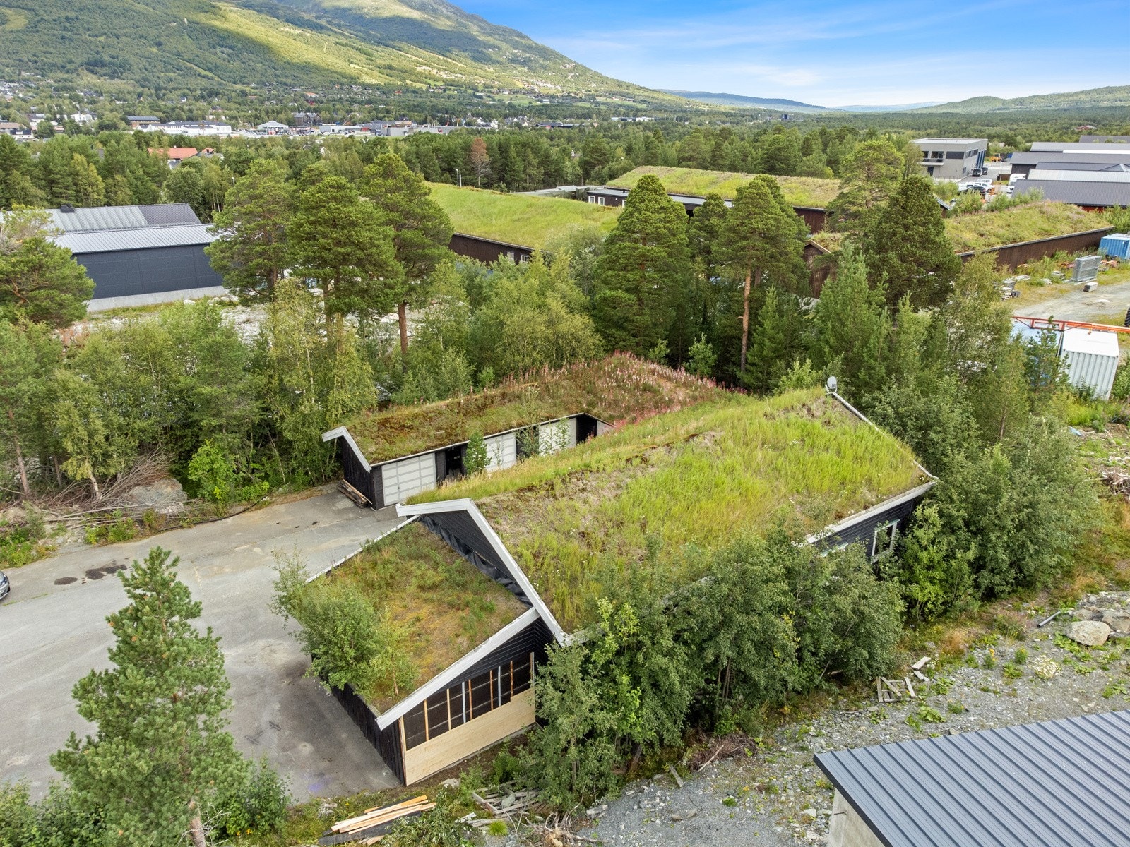 Stor eiendom fra år 1999, mørk kledning med torvtak. Galleribilde