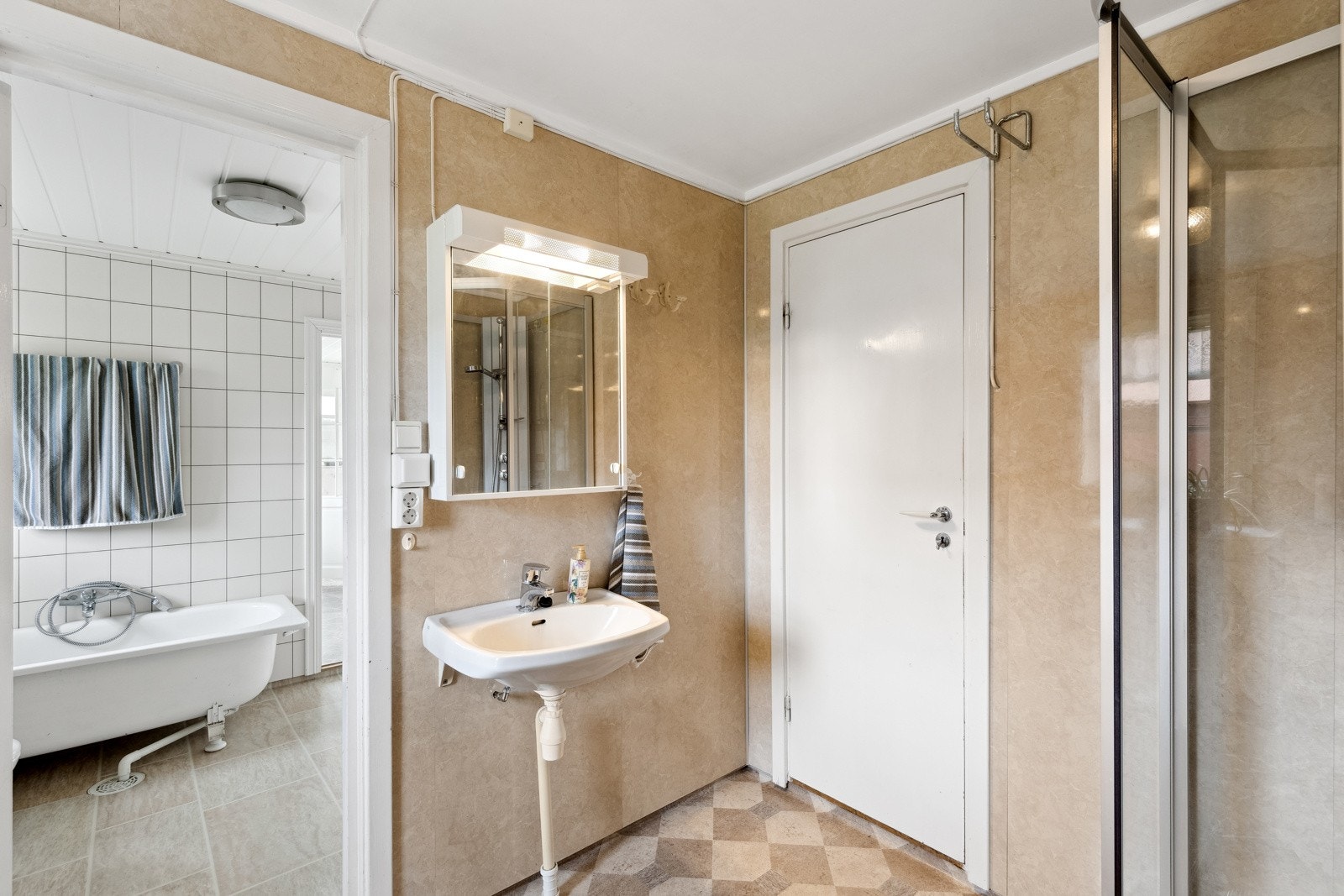 Badet i 1. etasje er et todelt rom, og har både badekar, dusj, wc og servant. Galleribilde