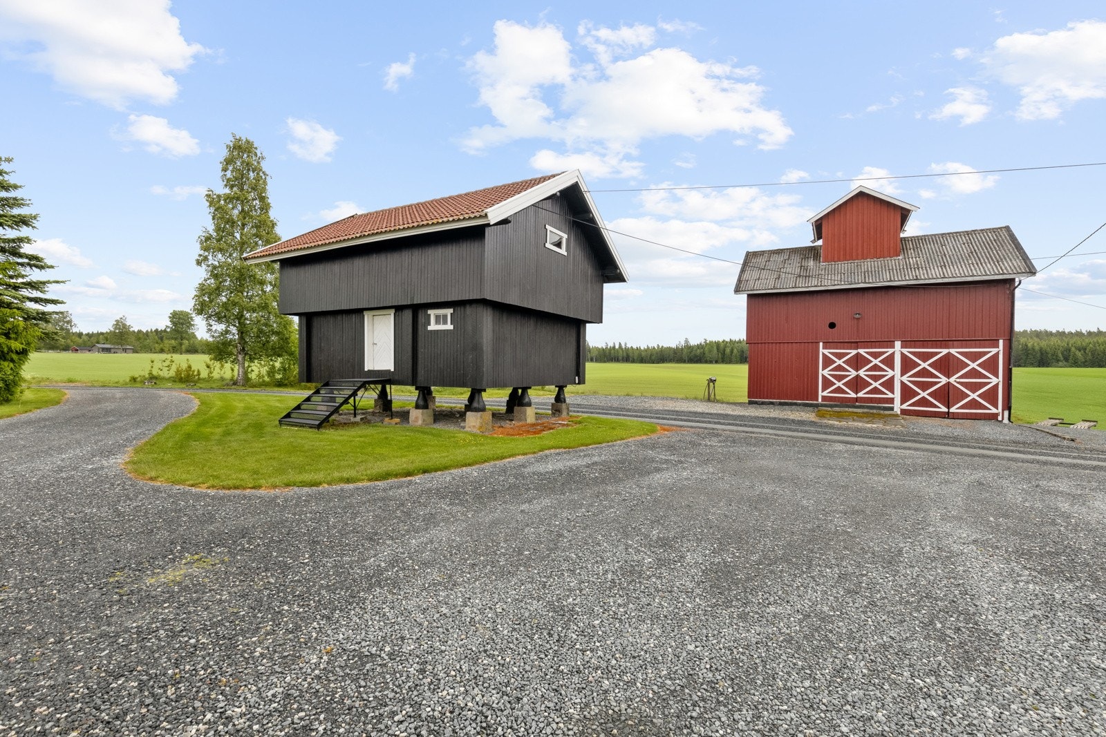Tunet har flere bygninger, blant annet dette stabburet over to etasjer, og korntørka som fortsatt er i aktiv drift Galleribilde