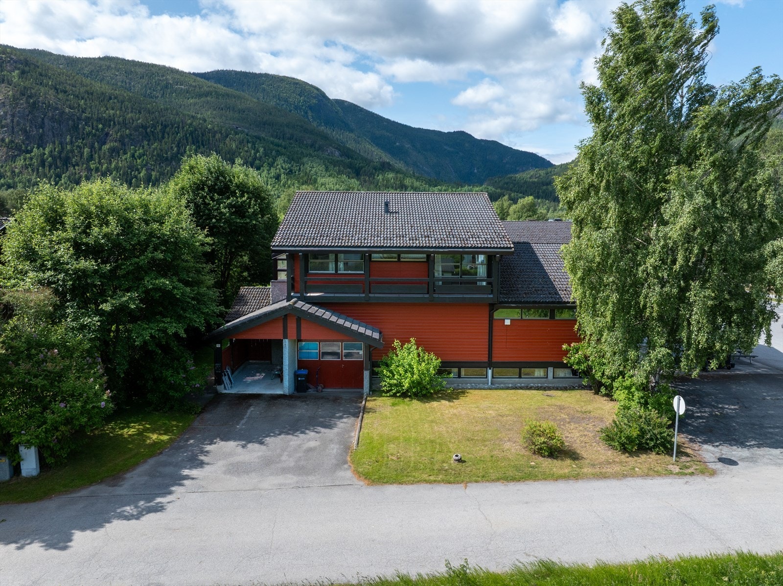 Boligen har egen carport på baksiden. Her finner med også porten ned til den store lagerkjelleren. Galleribilde