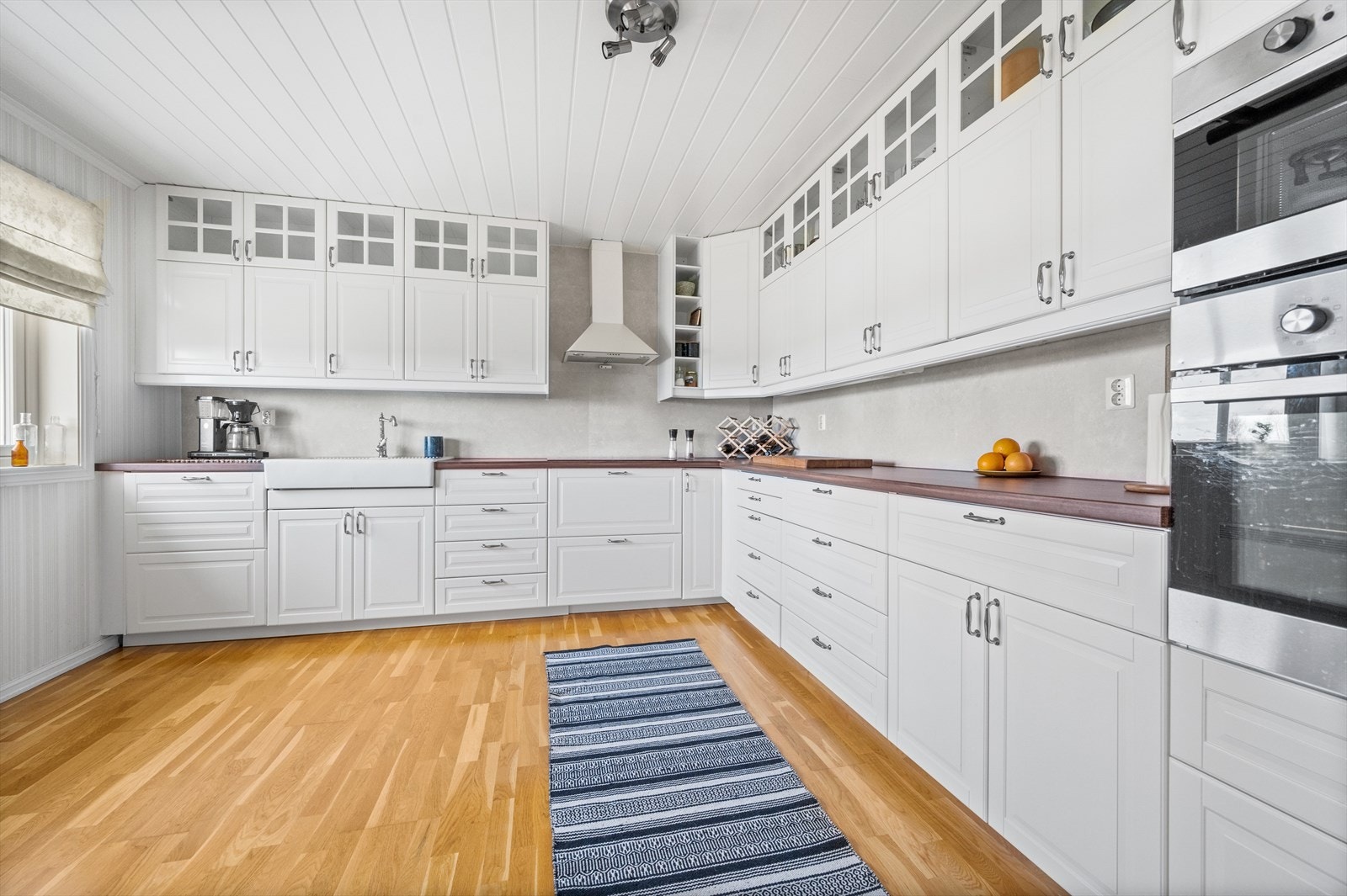 Kjøkkeninnredningen er i hvit profilert utsende, med laminat benkeplate. Vask av porselen med to kummer Galleribilde