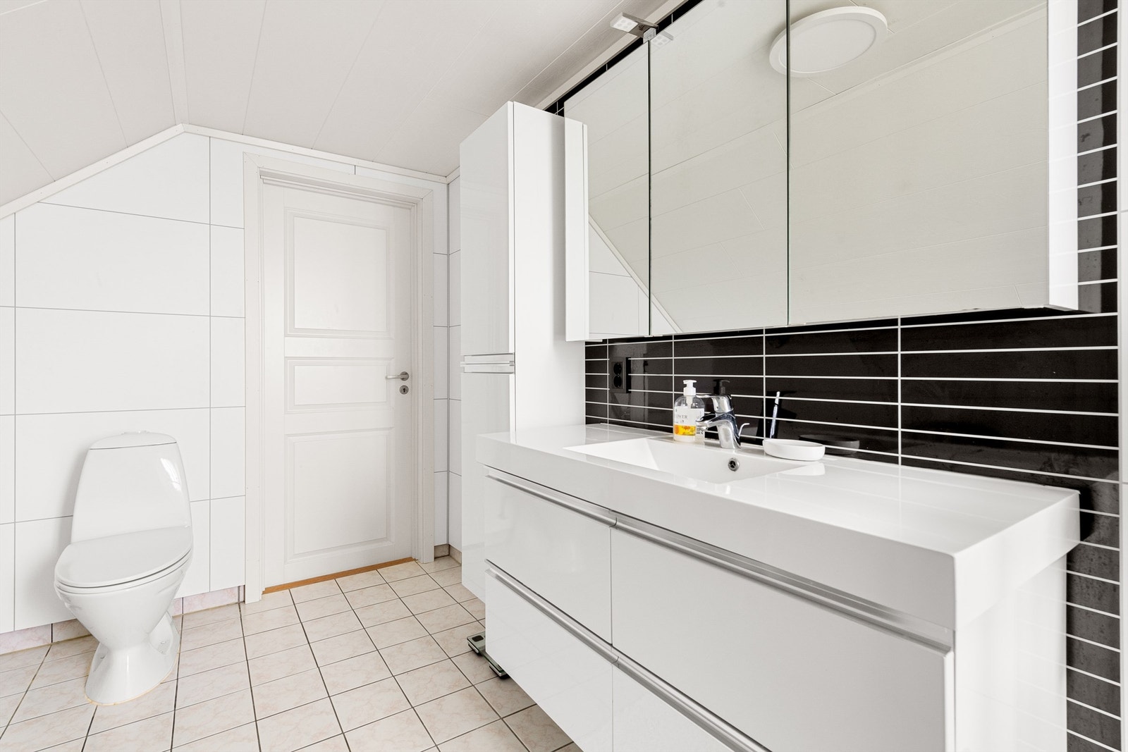 Bad i loftsetasje med baderomsinnredning, gulvmontert toalett, badekar og dusjkabinett Galleribilde