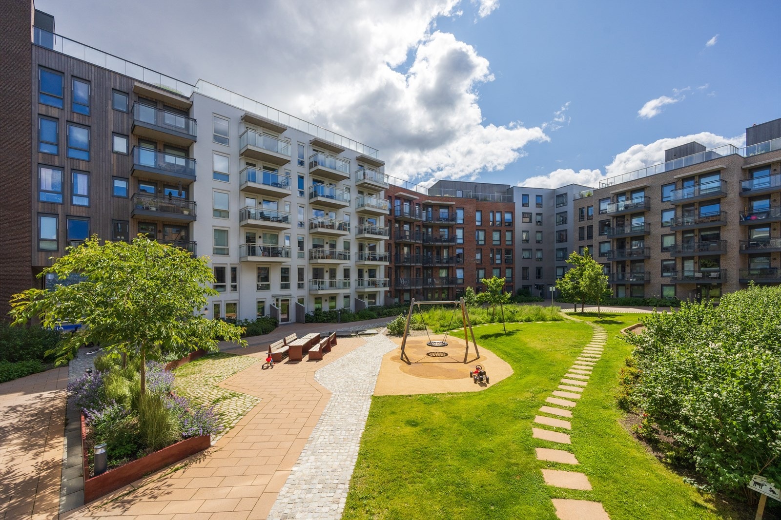 Rolig og frodig bakgård med lekeplass, sitteplasser og god plass for lek og hygge for både små og store. Galleribilde