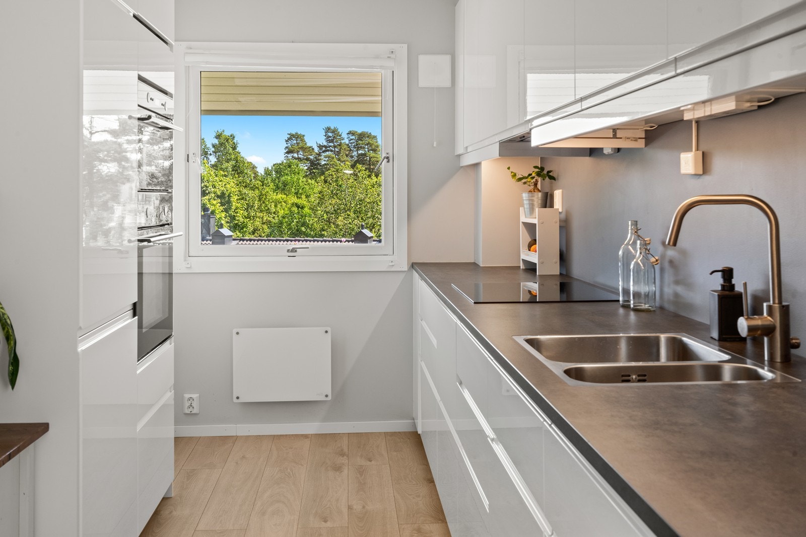 Kjøkken med glatte fronter og laminat benkeplate. Det er godt med skap og skuffer til kjøkkenartikler. Galleribilde