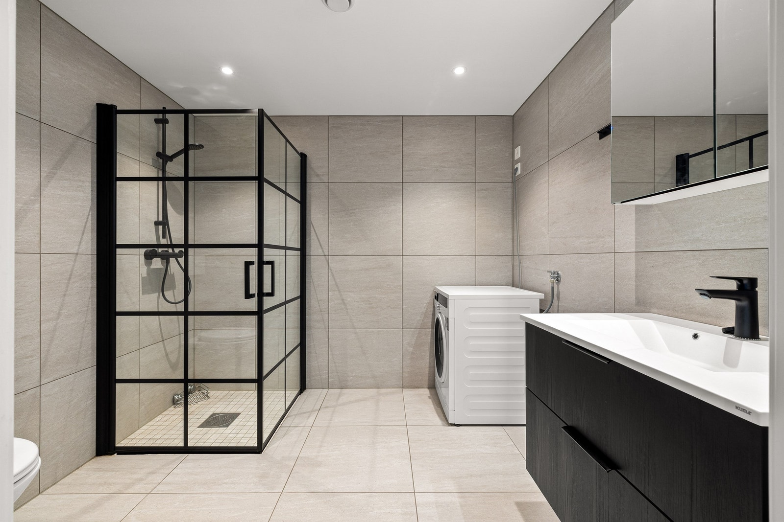 På badet er gulv og vegger utført med like storformat fliser som fremmer helhet. I gulvet er det naturligvis også varme. Galleribilde