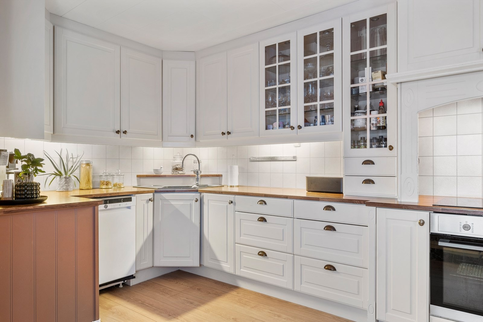 Kjøkkenet er lyst og har innredning fra 2008 med fronter i tre og noen med glassfelt, kjøkkenplater mellom benk og overskap, integrert komfyr og platetopp, øvrige hvitevarer og godt med benkeplass. Galleribilde