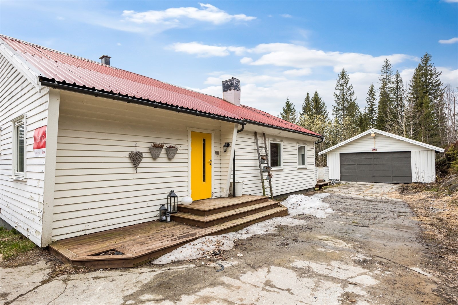 Mot inngangspartiet og garasjen. Fasaden mot Nord (til venstre i bildet) har behov for noe vedlikehold. Galleribilde