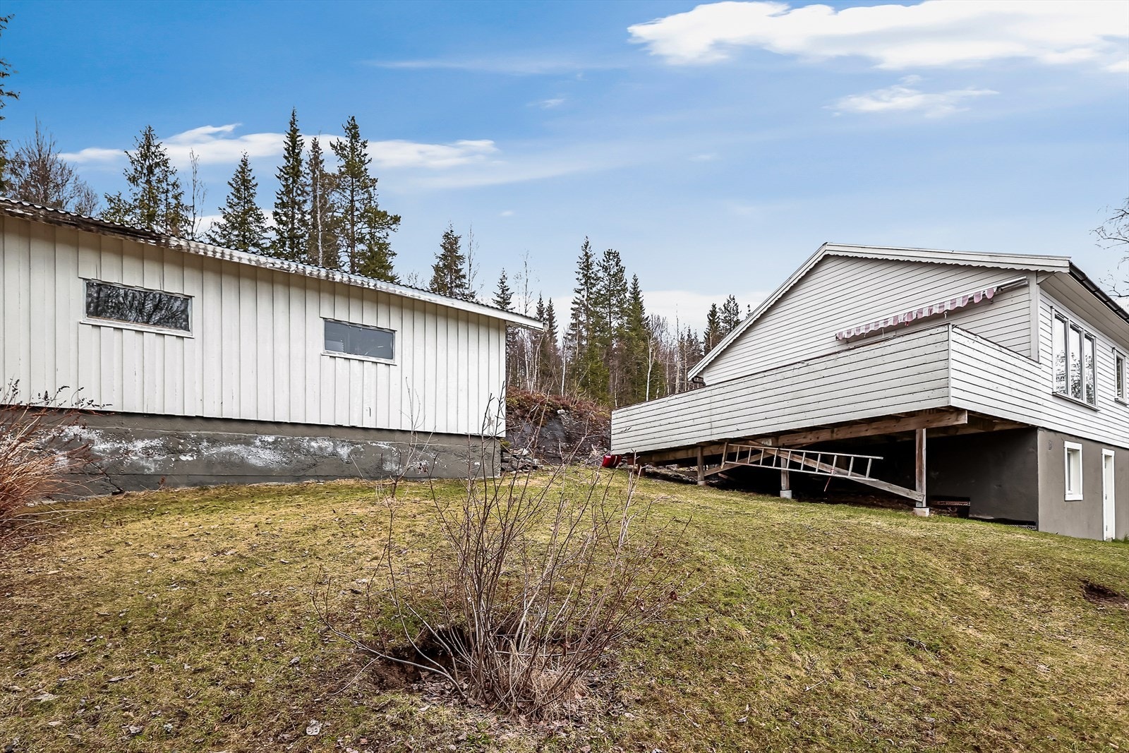 Eiendommen ligger i skrående terreng og har opparbeidet tomt med bl.a. plen, busker, trær og en romslig garasje. Galleribilde