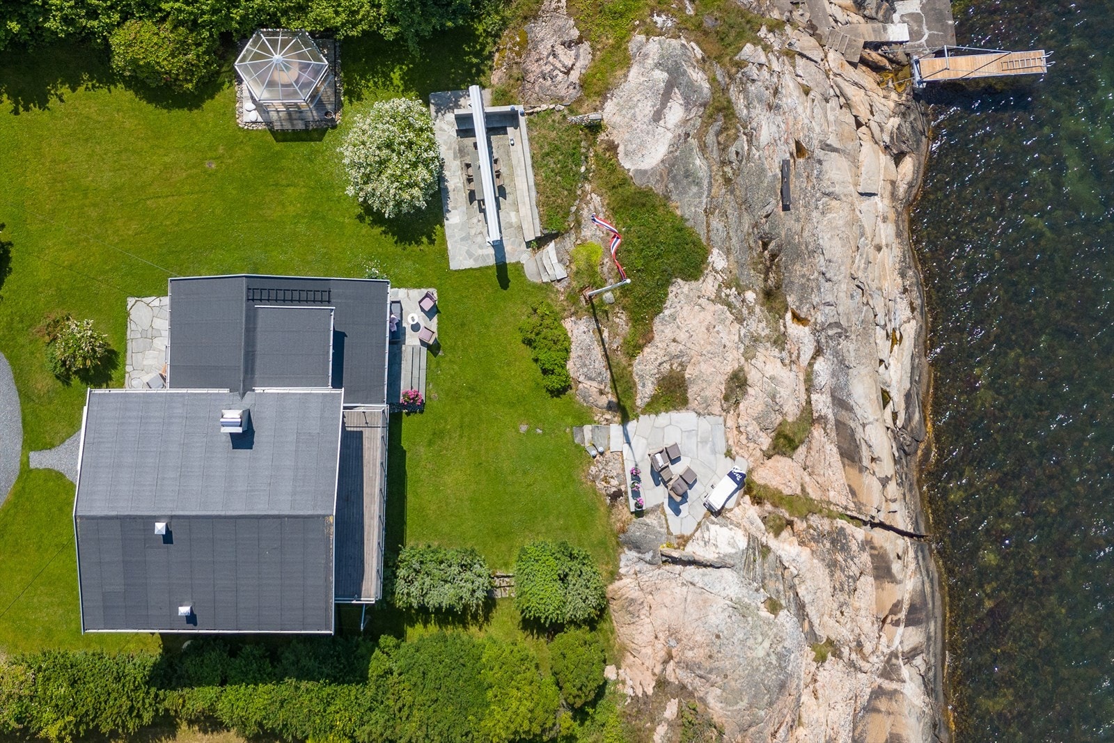 Eiendommen har egen strandlinje med idylliske svaberg og privat brygge perfekt for bading og båtliv. Galleribilde