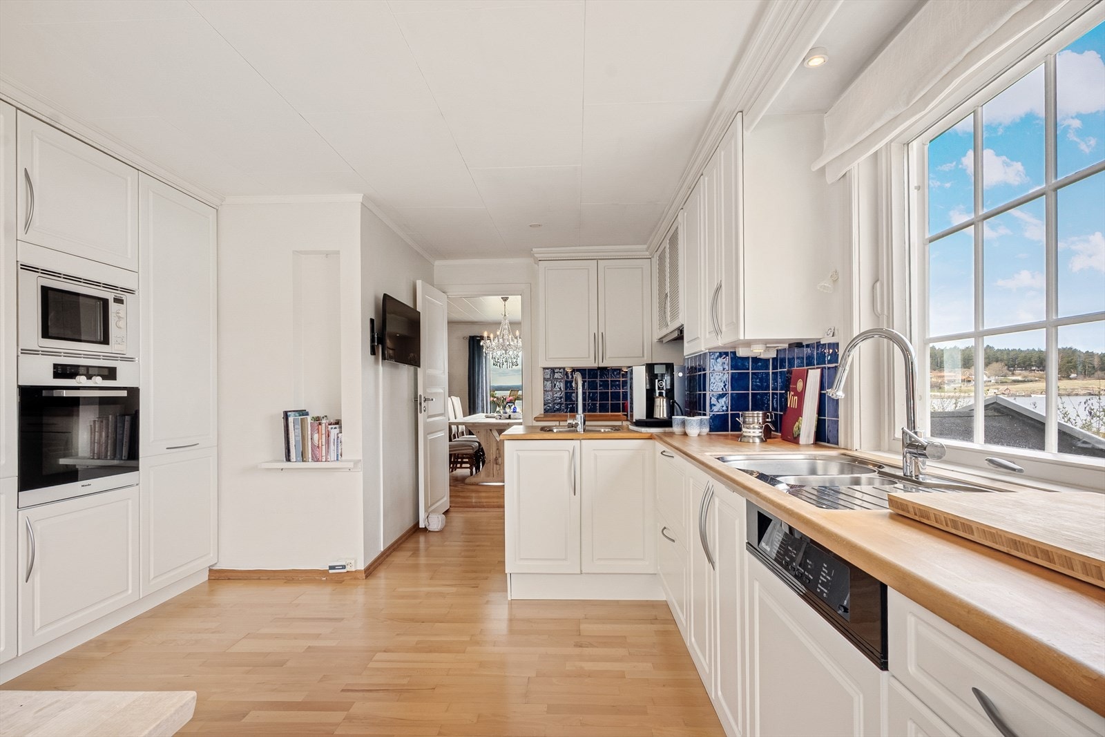 Et innholdsrikt kjøkken ligger i adskilt rom med lys, tidløs innredning og rikelig med oppbevaring. Galleribilde