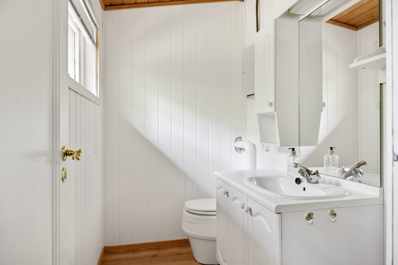 Wc-rom med separettoalett, servant med underskap, speil med lys over og sideskap. Galleribilde