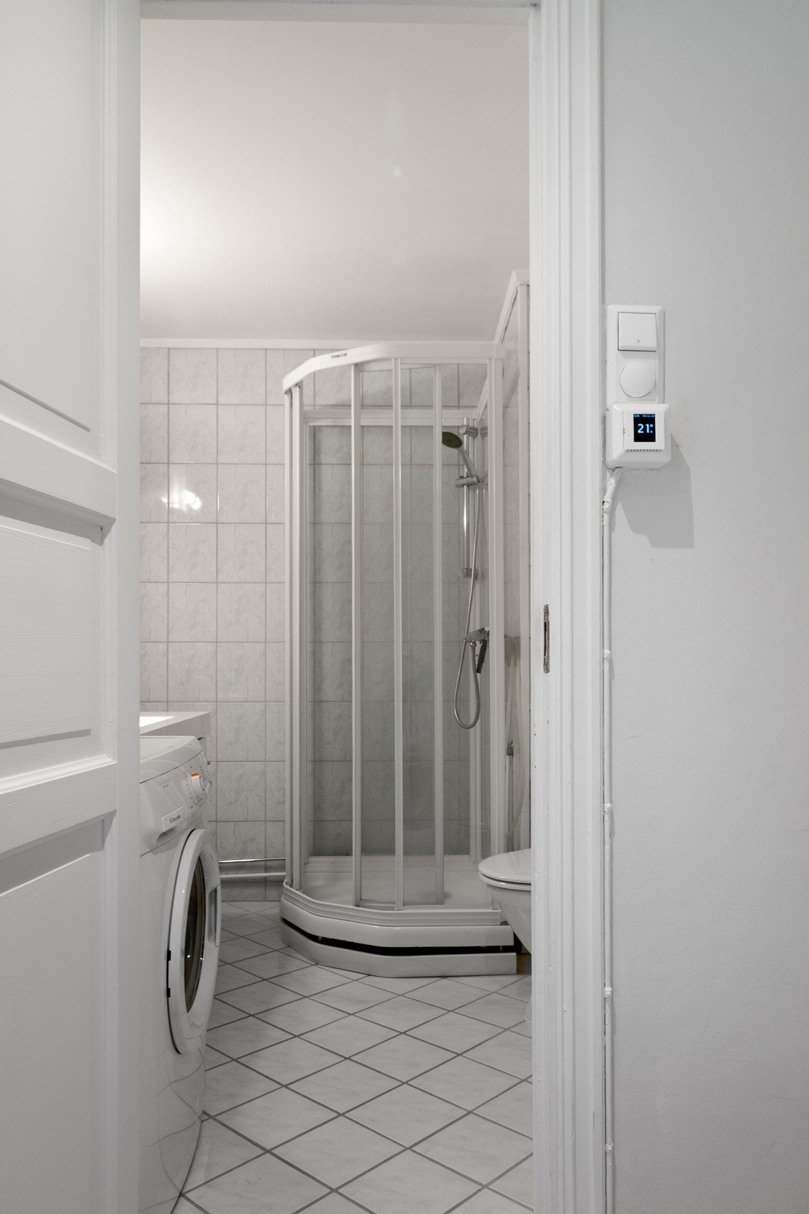 Badet er innredet med baderomsinnredning, dusjkabinett, toalett og opplegg for vaskemaskin. Galleribilde