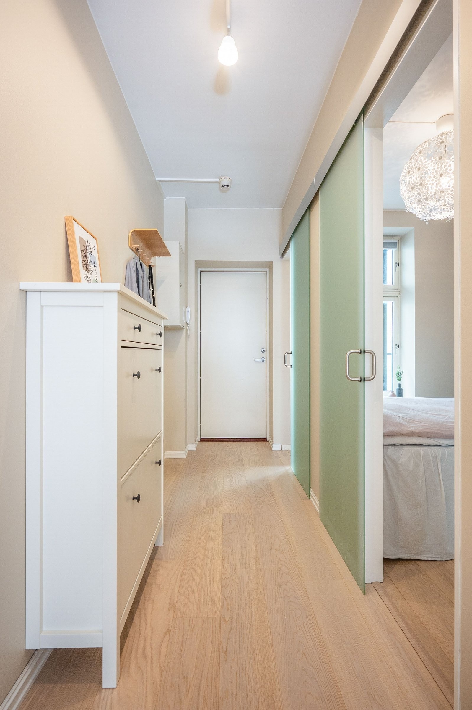 Romslig entré med god plass til å henge fra seg yttertøy og sko i praktisk skyveørsgarderobe. Galleribilde