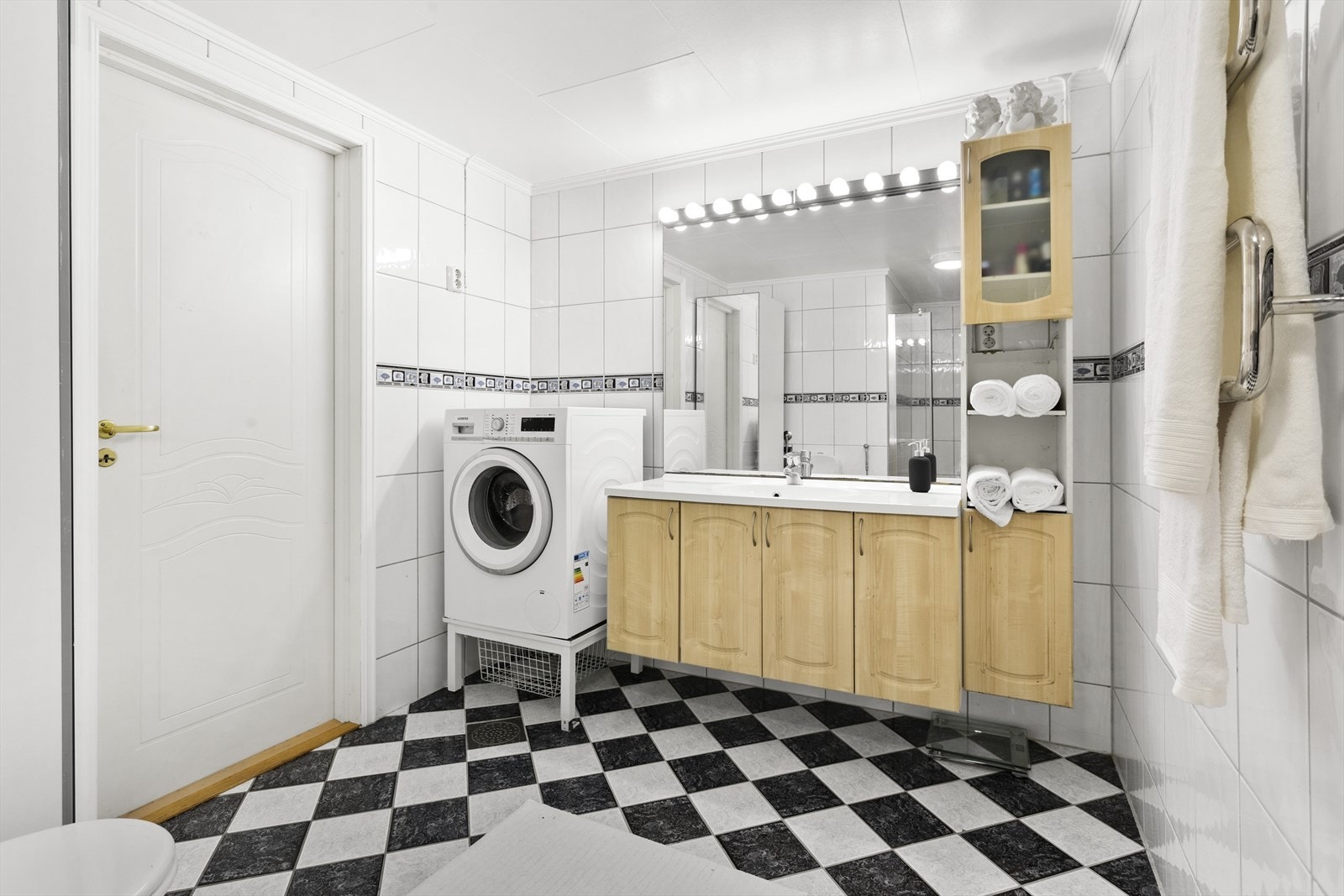 Det er 2 bad i kjelleretasjen. Etav badene er svært romslig og har sjakkmønstrede fliser på gulv, samt et tidløst og lyst design på veggene. Galleribilde