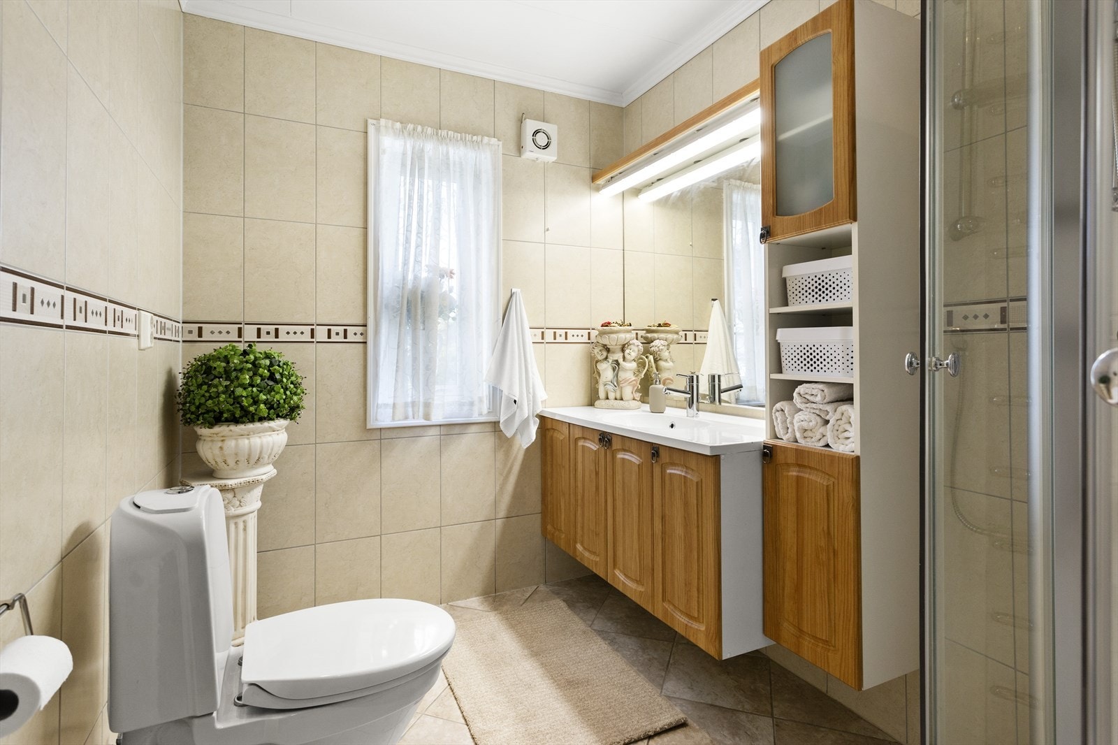 Til venstre fra entréen ankommer du badet i den første etasjen med fliser på gulv og vegger. Galleribilde