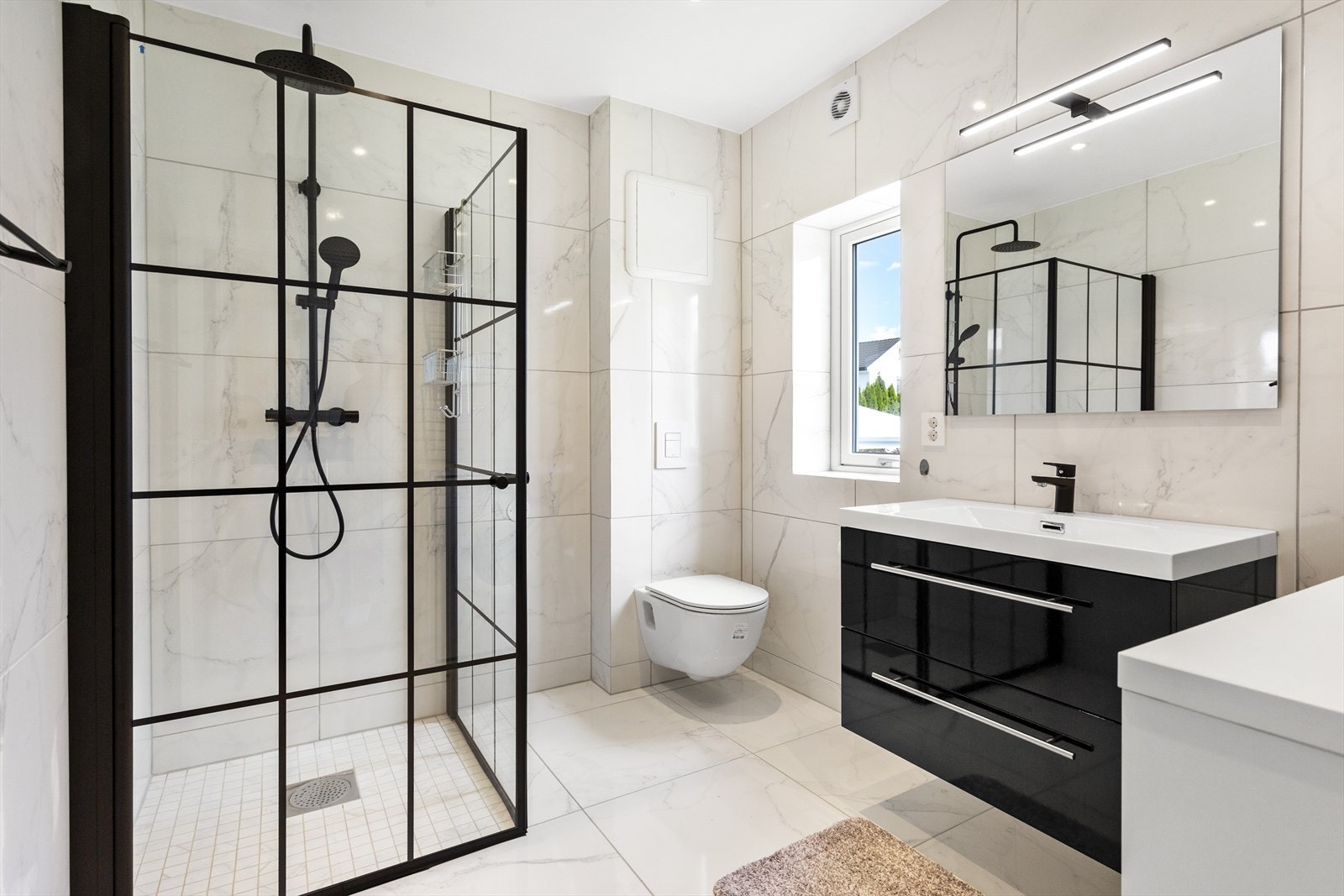 Badet i den første etasjen er nylig blitt renovert i 2022 og fremstår som svært moderne med stilige fliser på gulv og vegger. Galleribilde