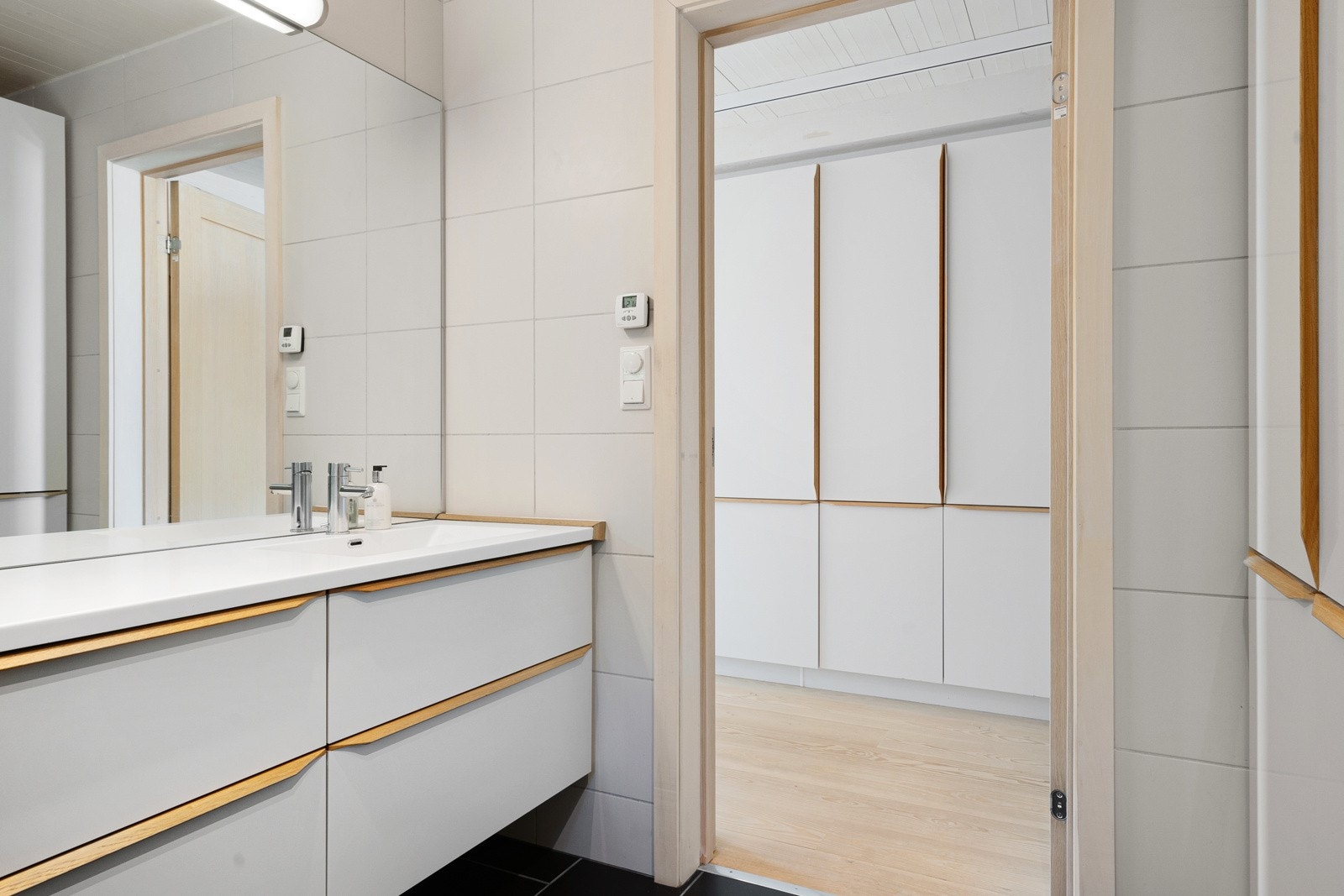 Baderommet ligger inn fra gangen, som har masse integrerte skaper langs hele veggen Galleribilde