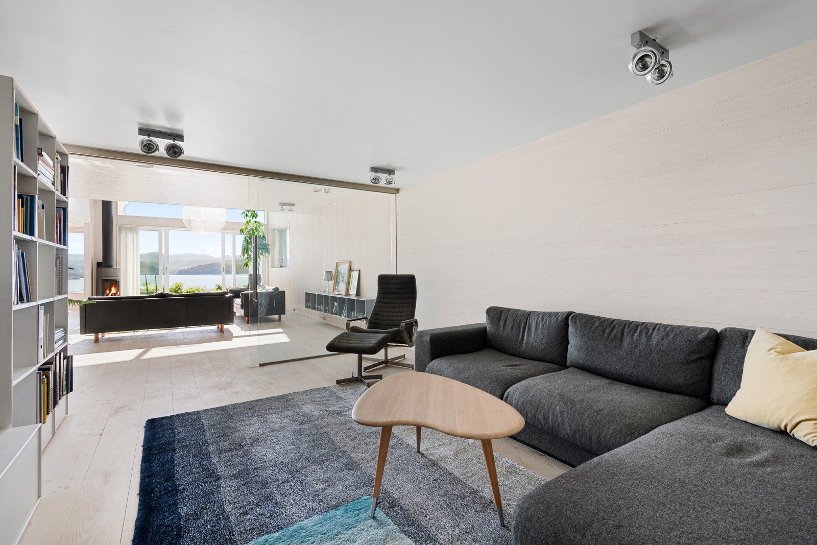 TV-stuen ligger innenfor stuen med glassvegg mellom Galleribilde