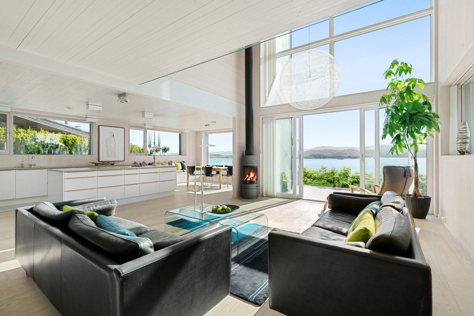 Stue med åpen kjøkkenløsning. Store vindusflater slipper inn masse dagslys. Usjenert. Galleribilde