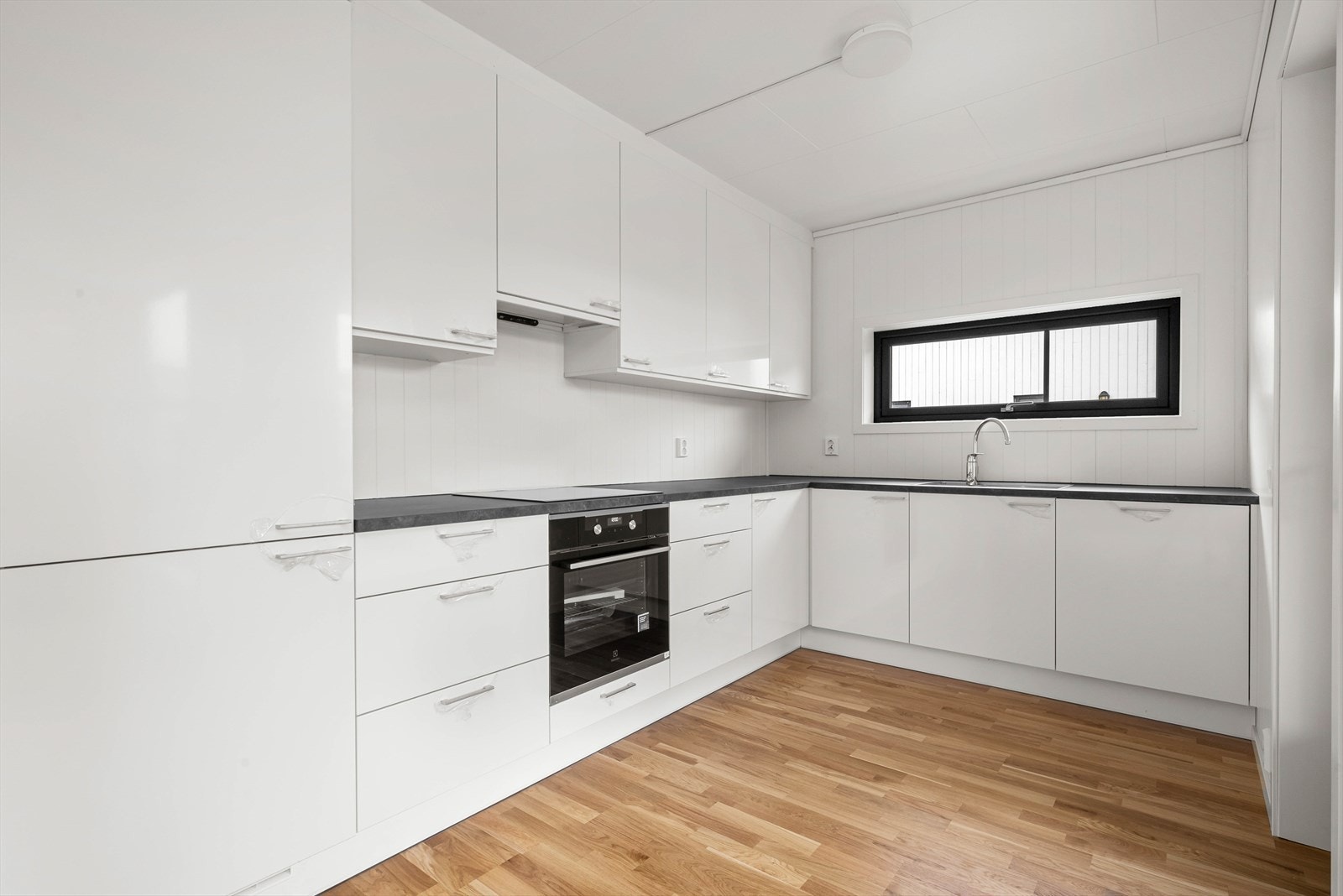 Kjøkkenet byr på integrerte hvitevarer og induksjonstopp. Galleribilde