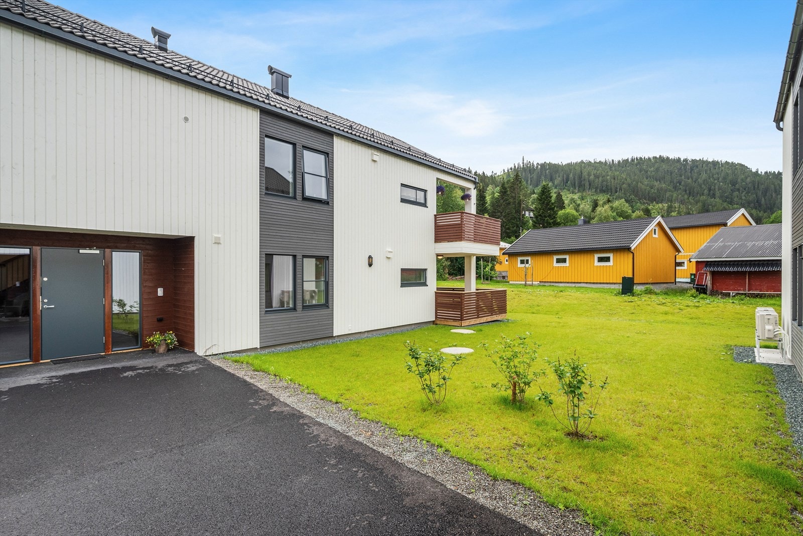 Utenfor leiligheten er det pent opparbeidet med flotte plenarealer og asfalterte gangveier. Galleribilde