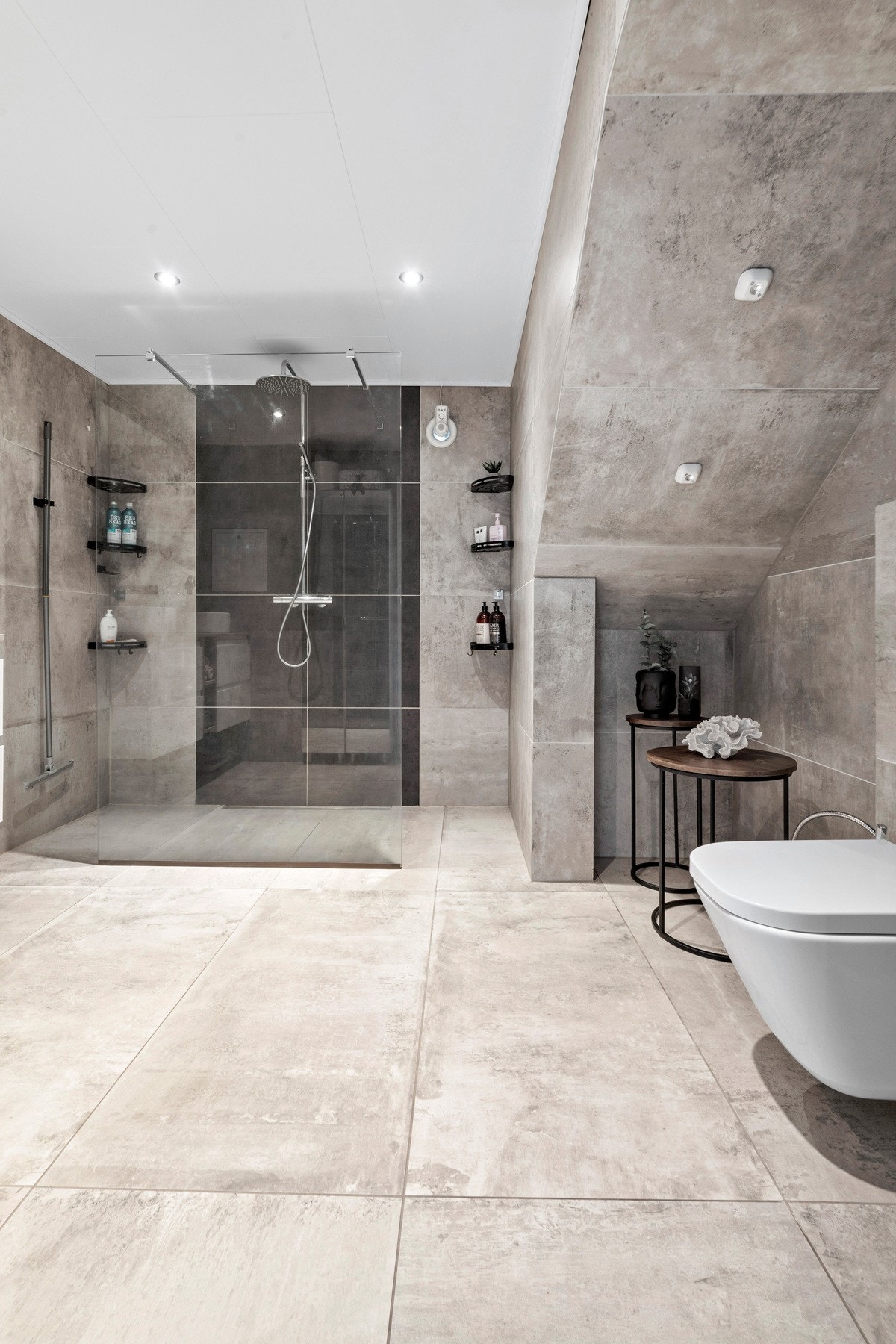 Badet i 1. etasje har downlights i himlingen, store, sandfargede fliser på veggene og matchende fliser på gulvet. Galleribilde