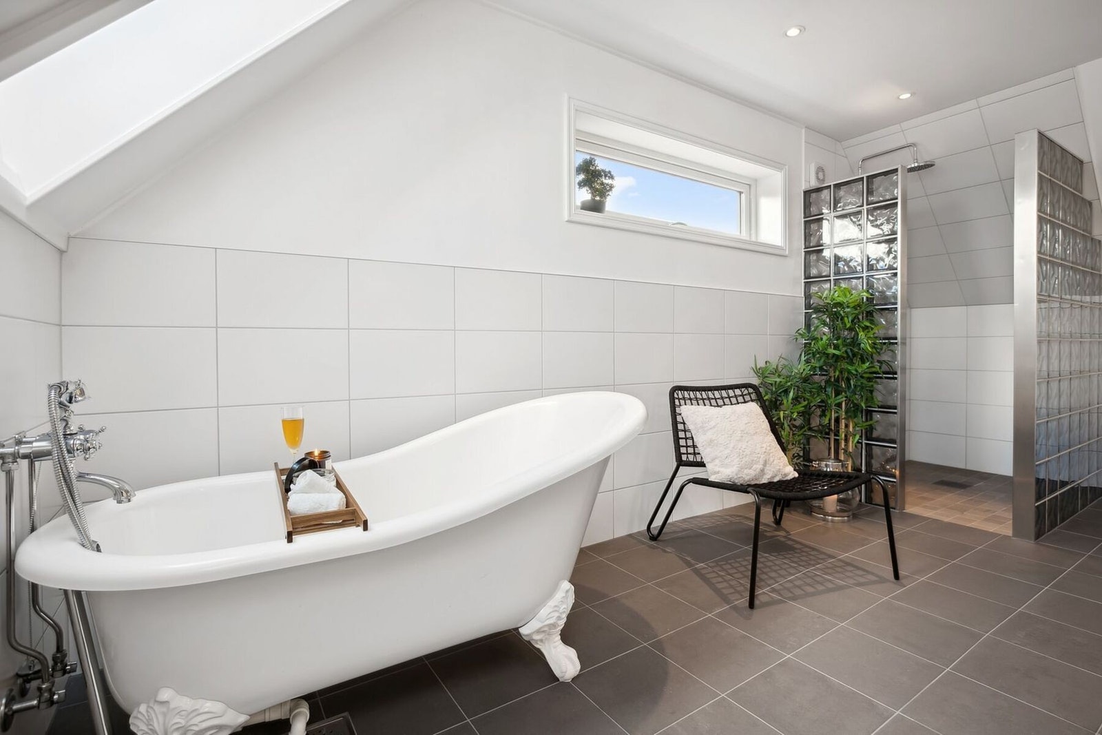 Baderommet har romslig innredning med servant, dobbelt blandebatteri, speil med integrert belysning, badekar med løveføtter og dusjnisje med glassbyggerstein, samt flott regnfallsdusj. Galleribilde