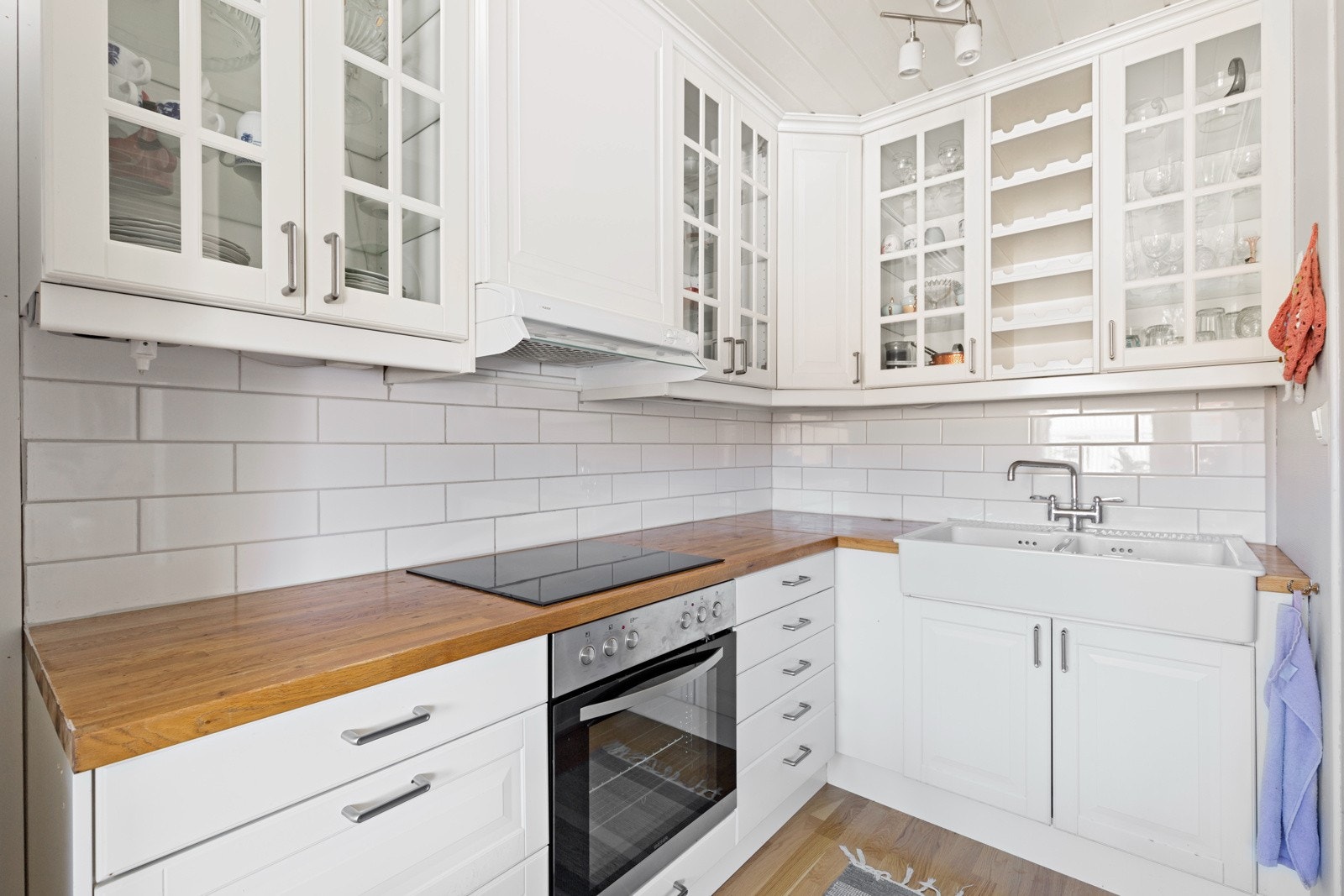 Pent kjøkken med profilerte fronter og benkeplater i heltre Galleribilde