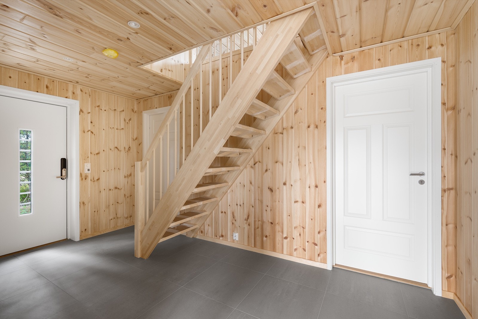 Entreen er stor og praktisk med plass til garderobeløsning, og har trehvitt panel, downlights, store gulvfliser og varmekabler. Trepanelet gir et solid og varmt inntrykk. Galleribilde