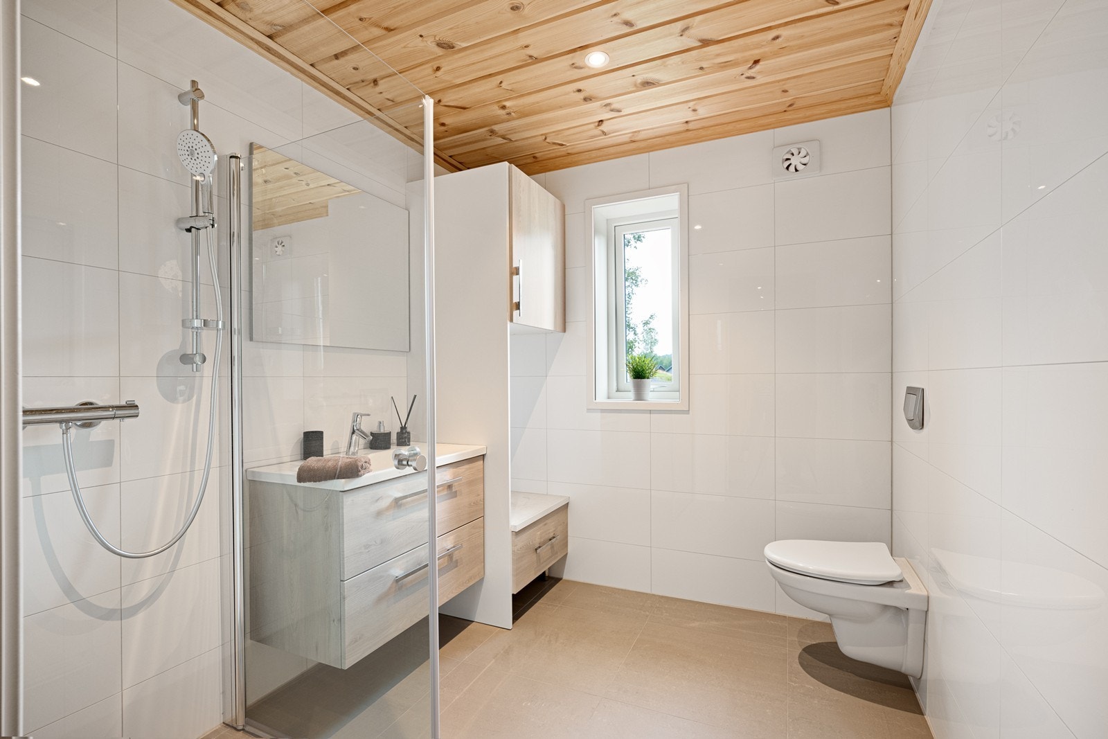Det delikate flislagte badet har varmekabler i gulvet, downlights i himling og mekanisk avtrekksvifte i vegg. Galleribilde