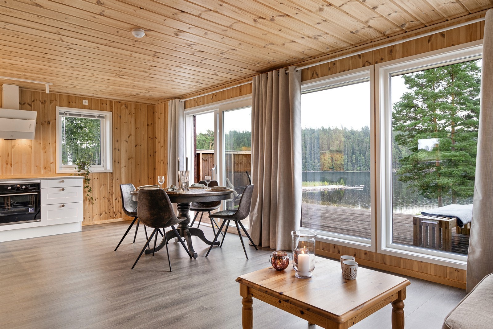 Stua og kjøkkenet har uhindret utsikt rett til vannet. I tillegg er det gjennomgående lys fra vinduer på øst- og vestveggen. Galleribilde