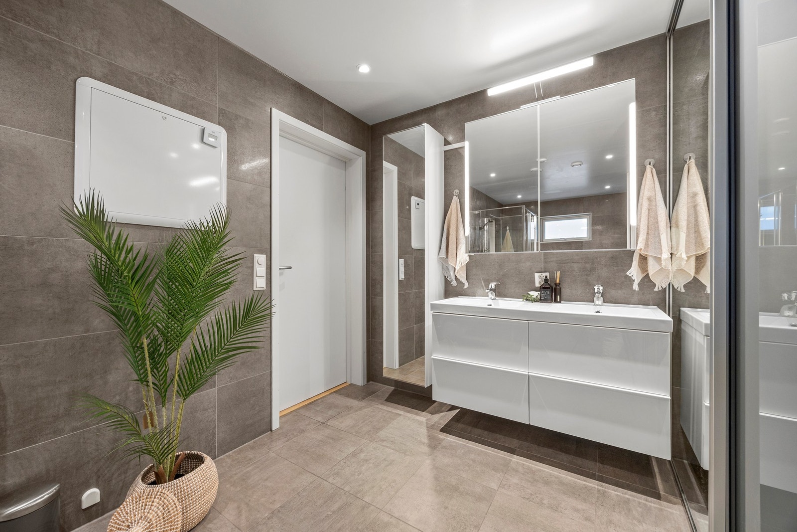 Utstyrt med servantskap, dusj og skyvedørsgarderobe som skjuler vaskeromsdelen Galleribilde