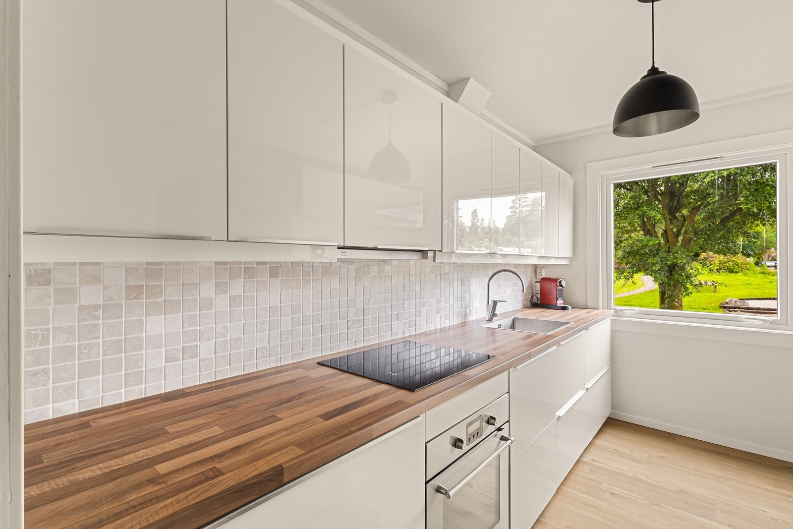 Leiligheten har en pen og tidløs kjøkkeninnredning med slette fronter og benkeplate i laminat Galleribilde