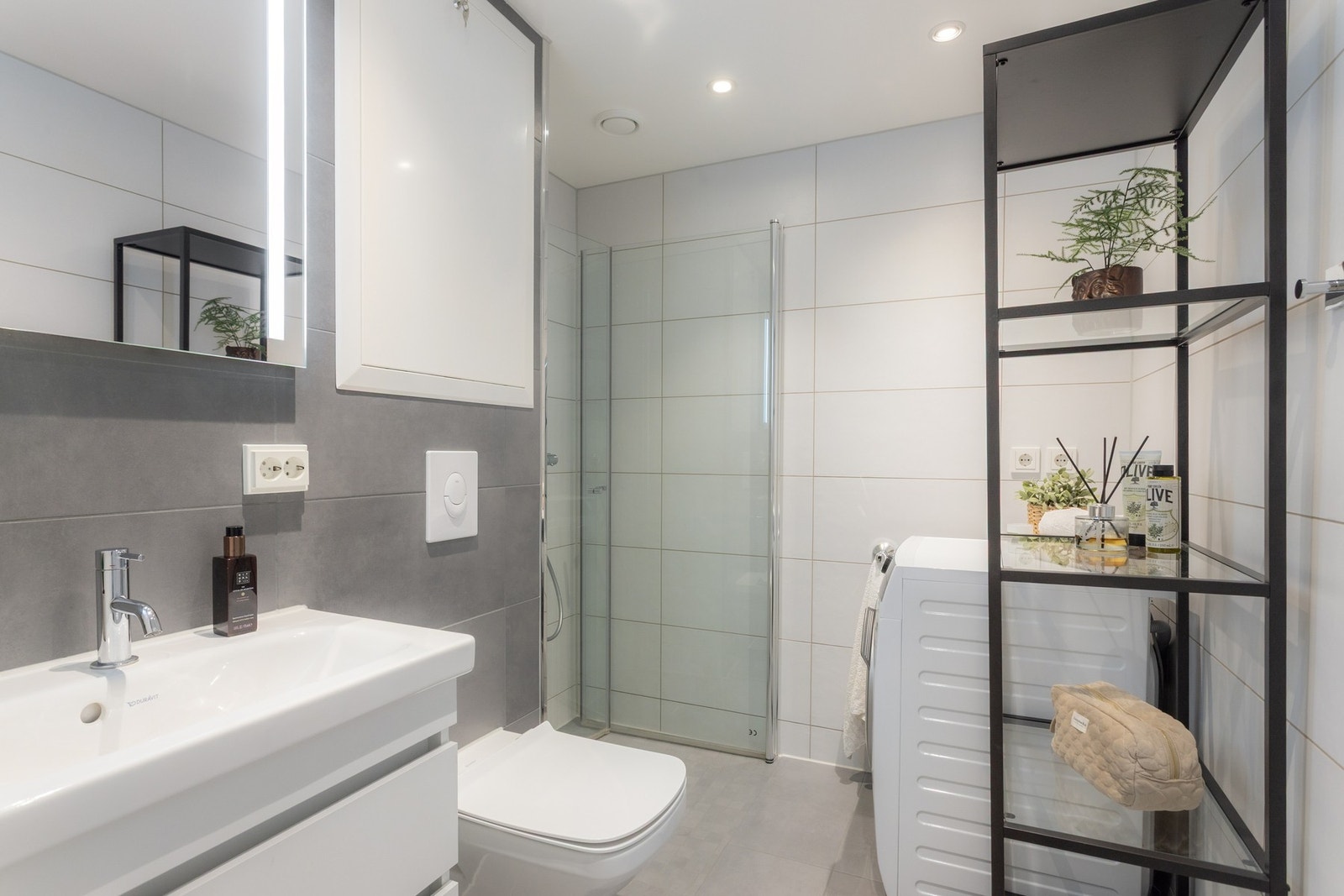 Moderne og flislagt baderom med god størrelse samt opplegg for vaskemaskin og tørketrommel Galleribilde