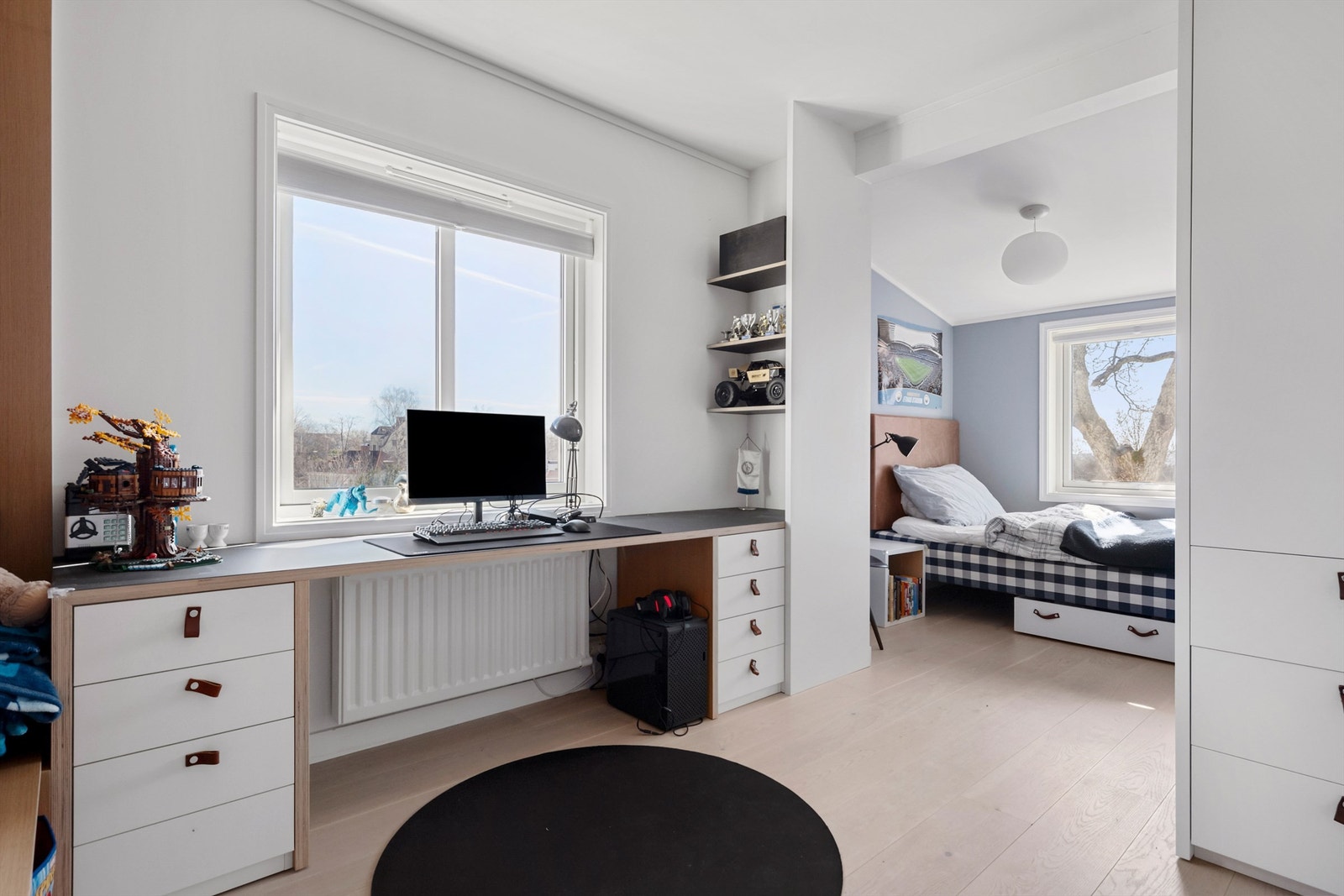 Del av soverom 3 som er 2-delt med seng innerst og pult, sofa og garderobeskap i andre del. Galleribilde