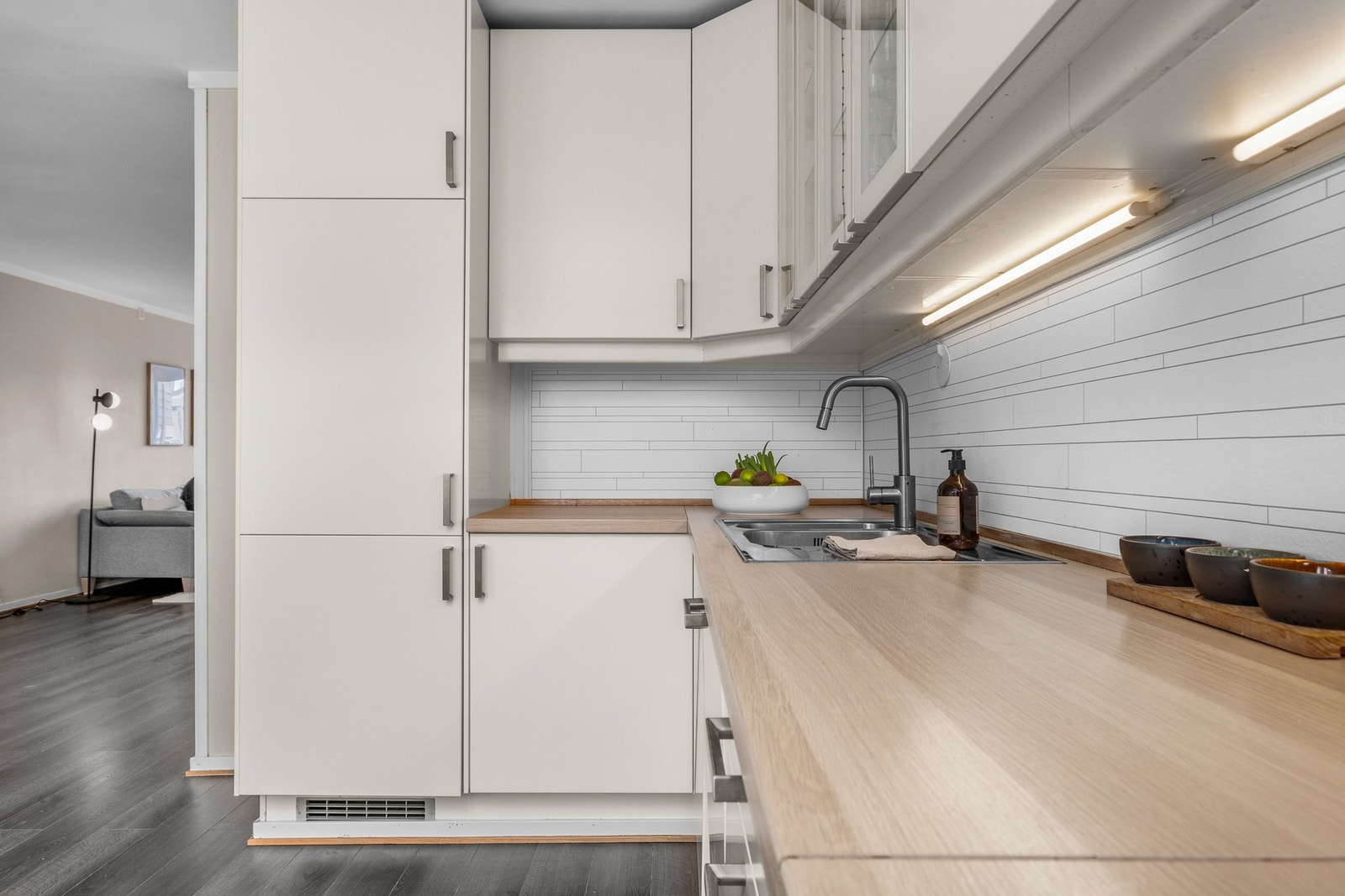 Glatte fronter med laminert benkeplate. Integrerte hvitevarer består av induksjon platetopp, komfyr og oppvaskmaskin. Galleribilde