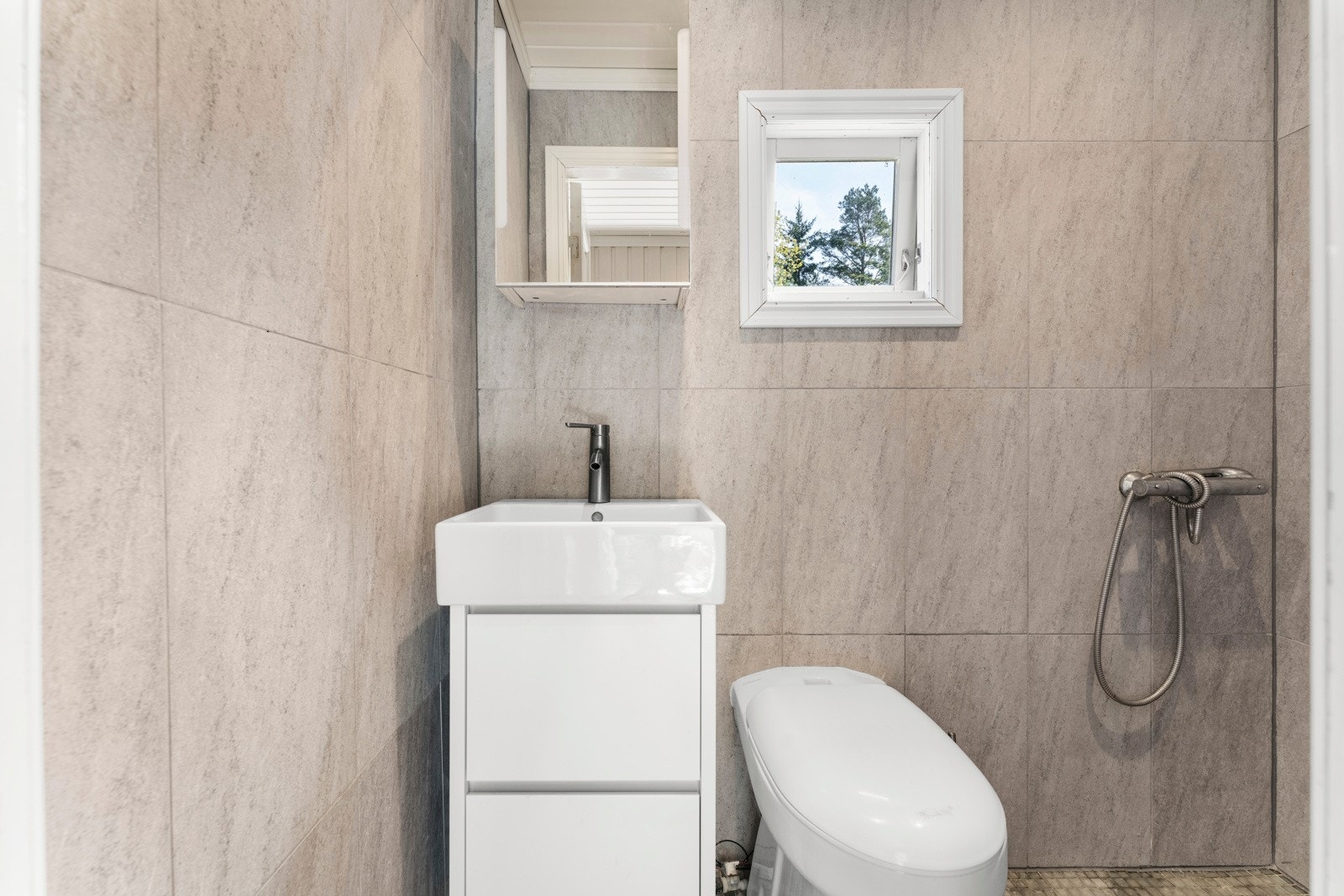 Boligen har et bad i første etasje og et bad/vaskerom i underetasjen. Dette er badet i første etasje. Galleribilde