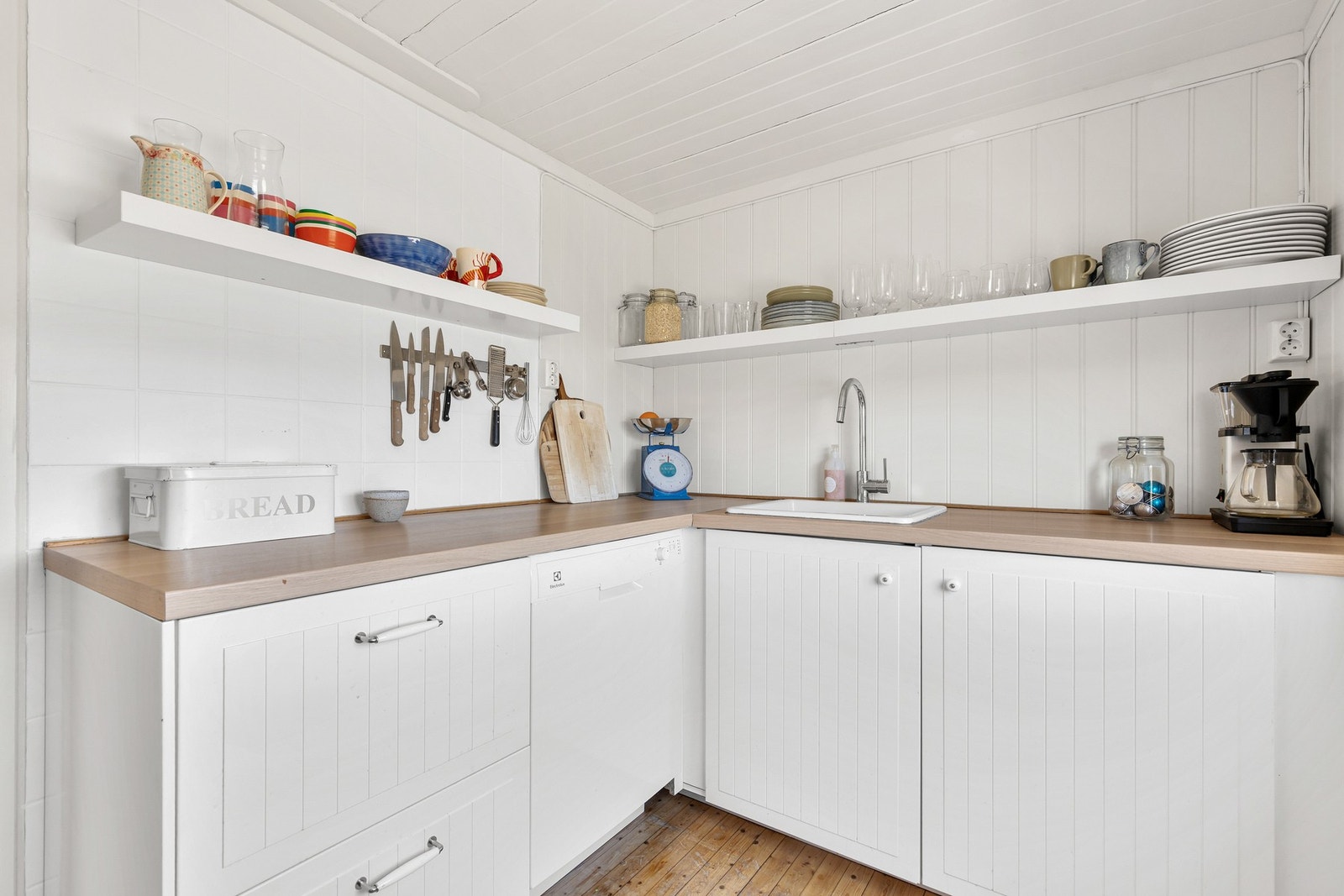 Kjøkkenet er utstyrt med oppvaskmaskin under benk, frittstående komfyr og frittstående kjøleskap med fryser Galleribilde