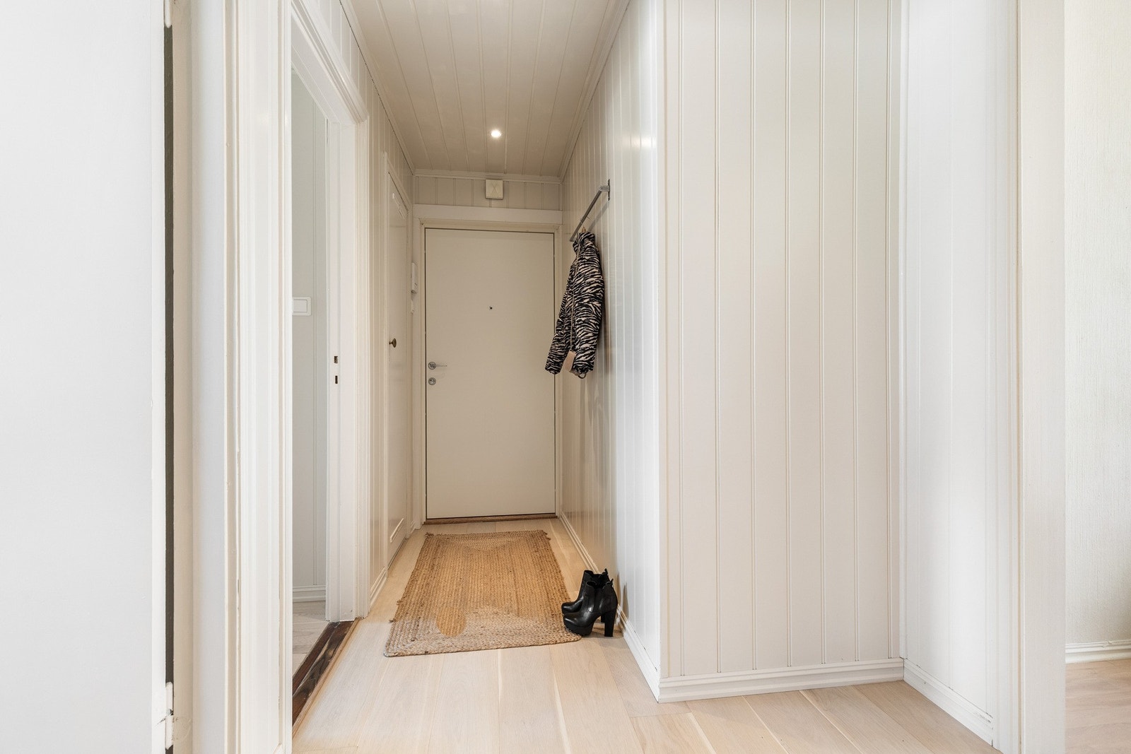 Lys og romslig entré med panelvegger og lys parkett. Galleribilde