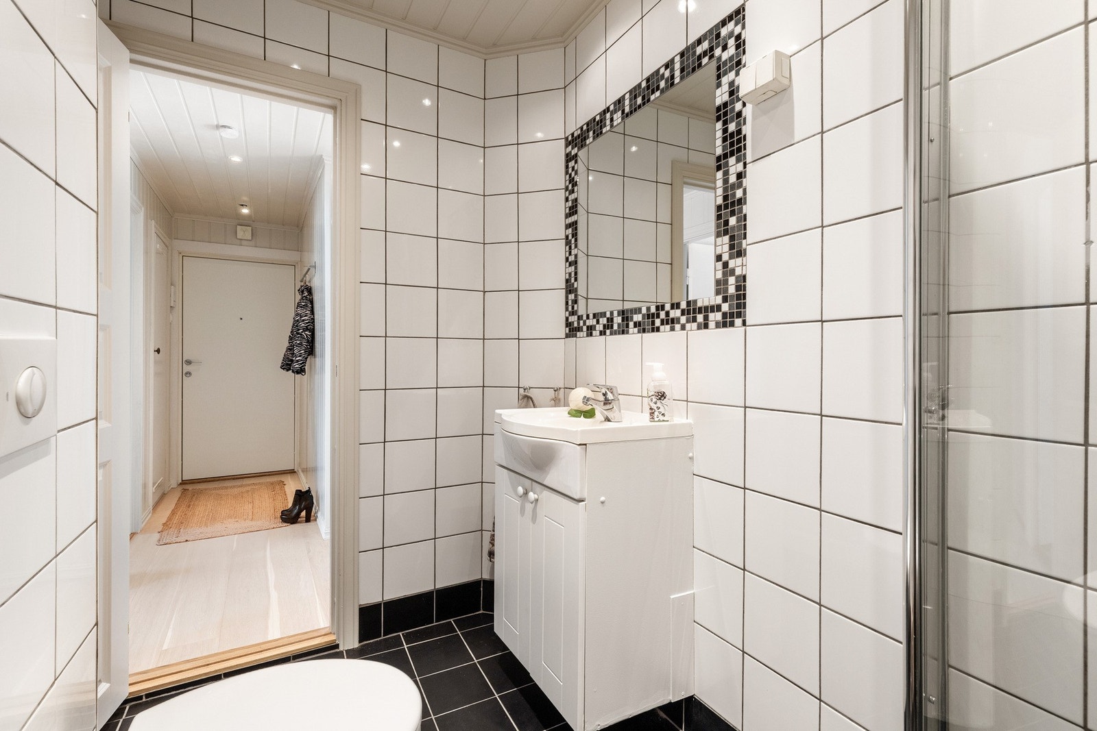 Innredningen består av servant med underskap og speil med dekorative fliser. Galleribilde