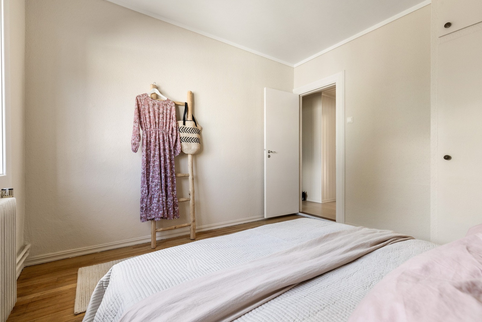 Lyst soverom med tregulv og nøytrale farger. Galleribilde