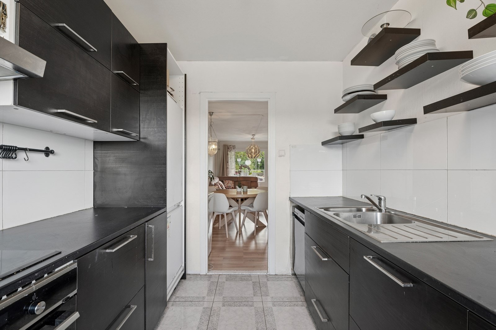 Kjøkkenet er stilrent med slette fronter og hyller til oppbevaring. Galleribilde