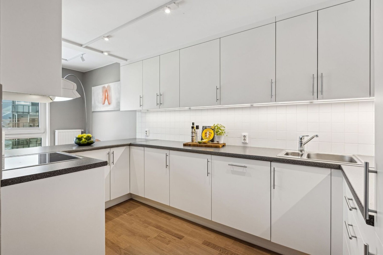 Det er rikelig med skapplass og gode arbeidsflater, samt en åpning mot stuen som gir utsyn til vinduet. Galleribilde