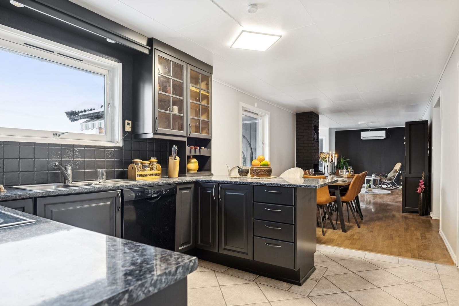 Mørk kjøkkeninnredning med profilerte fronter og benkeplater i laminat. Galleribilde