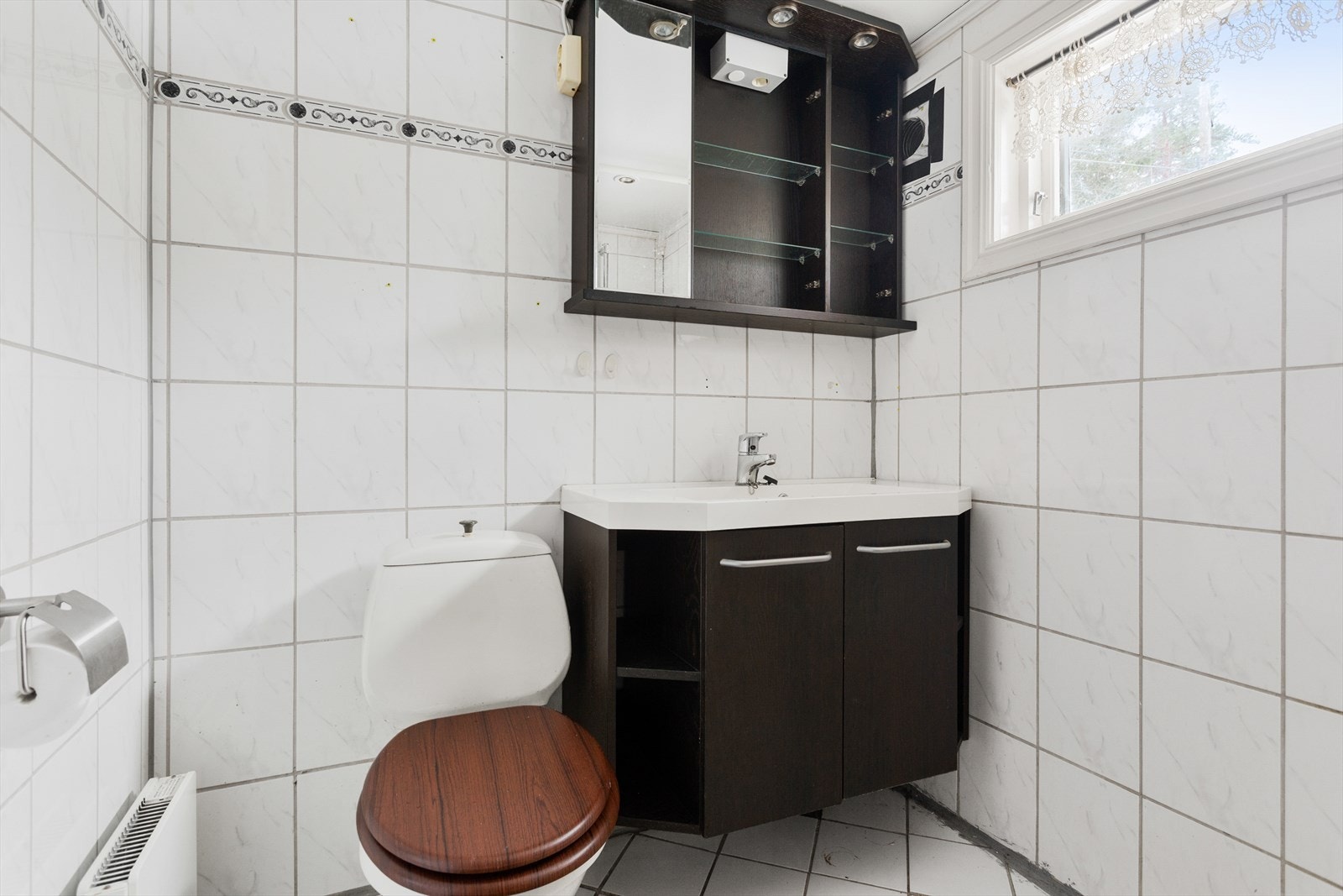 Det er elektriske varmekabler i gulvet, samt naturlig ventilasjon med ventil i vegg. Det er flere sprukne og løse fliser i gulv. Badet må påregnes renovert. Galleribilde