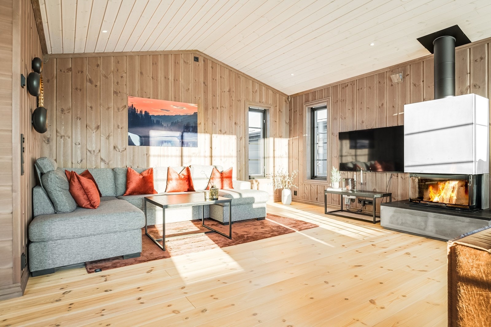 Som et fint midtpunkt i stuen er det en lekker elementpeis som både gir god varme og bidrar til ekstra hygge. Galleribilde