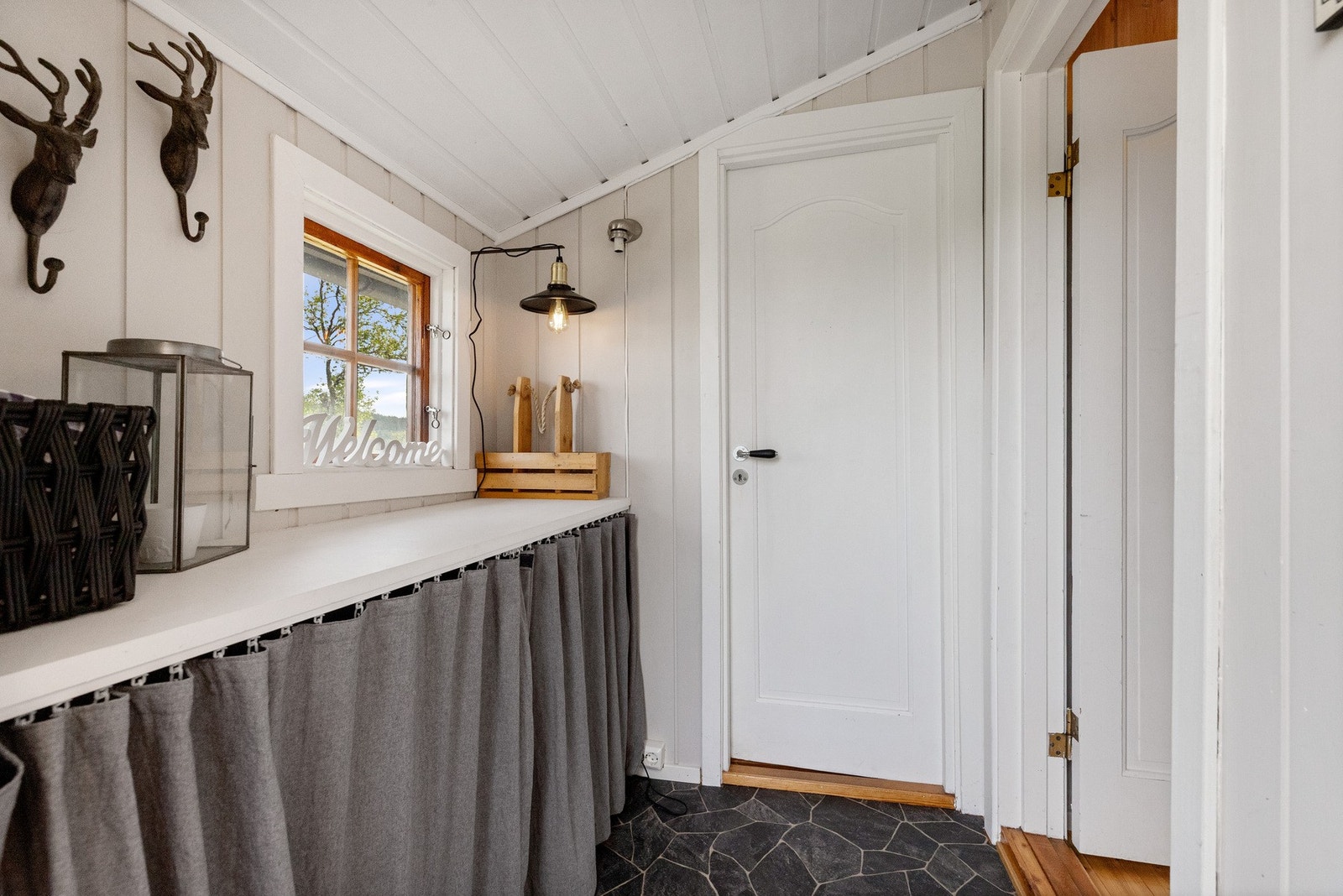 Entré med plassbygd benk og oppbevaringsmuligheter under benk Galleribilde