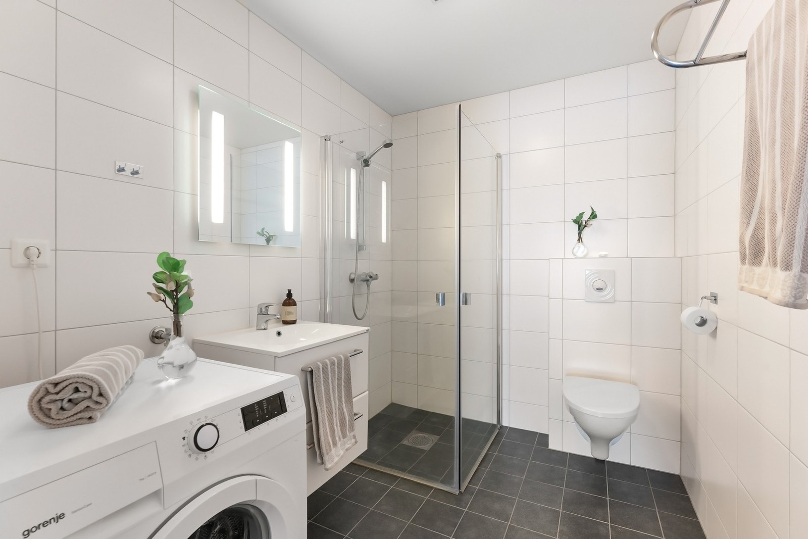 Badet i utleiedelen er innredet med vegghengt toalett, dusjhjørne med innfellbare glassdører og baderomsinnredning. Galleribilde