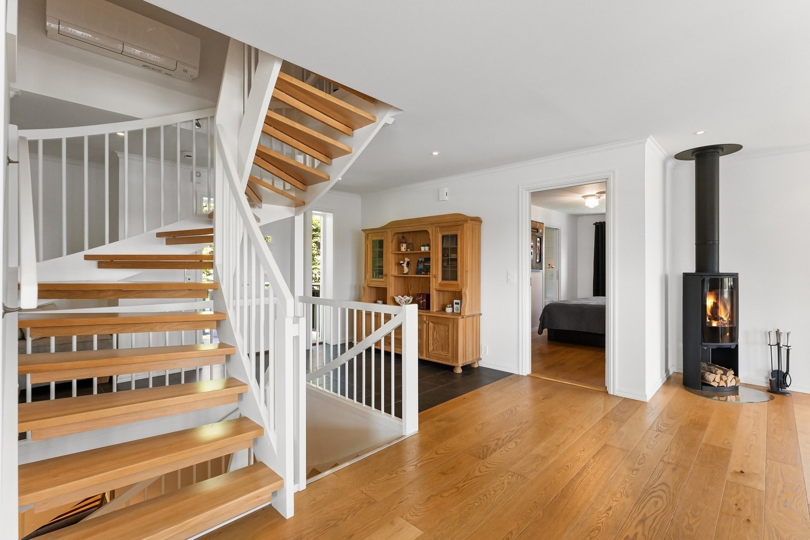 Lyst og luftig hall med trapp og peisovn. Galleribilde